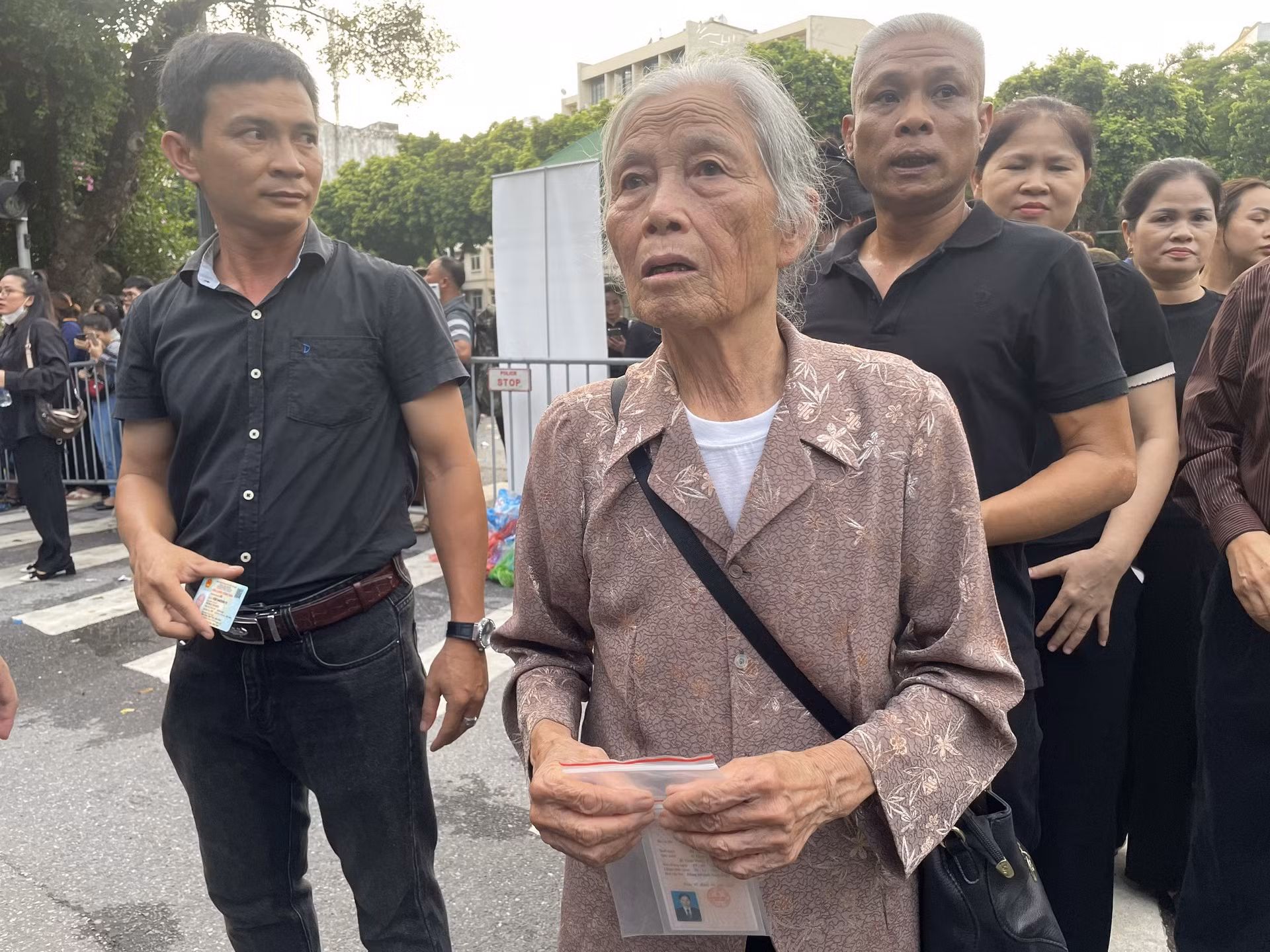 Bà Hoàng Thị Mến cầm trên tay tấm thẻ đảng viên vào viếng Tổng Bí thư.