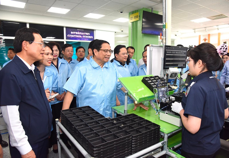 Thủ tướng Phạm Minh Chính thăm hỏi công nhân dây chuyền sản xuất thiết bị điện tử của Công ty TNHH Samsung Electronics Việt Nam.