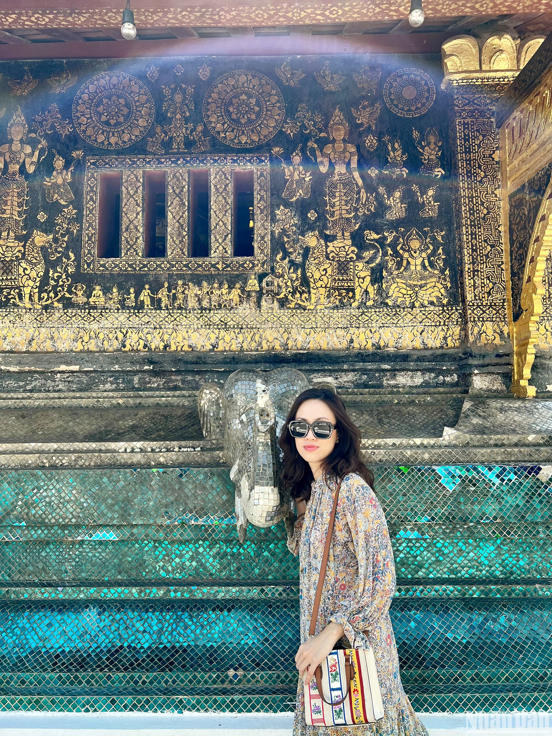 Du khách tranh thủ lưu lại những chi tiết, họa tiết đặc sắc được trang trí tinh tế trên những bức tường của Wat Xiengthong. (Ảnh: TRỊNH DŨNG)