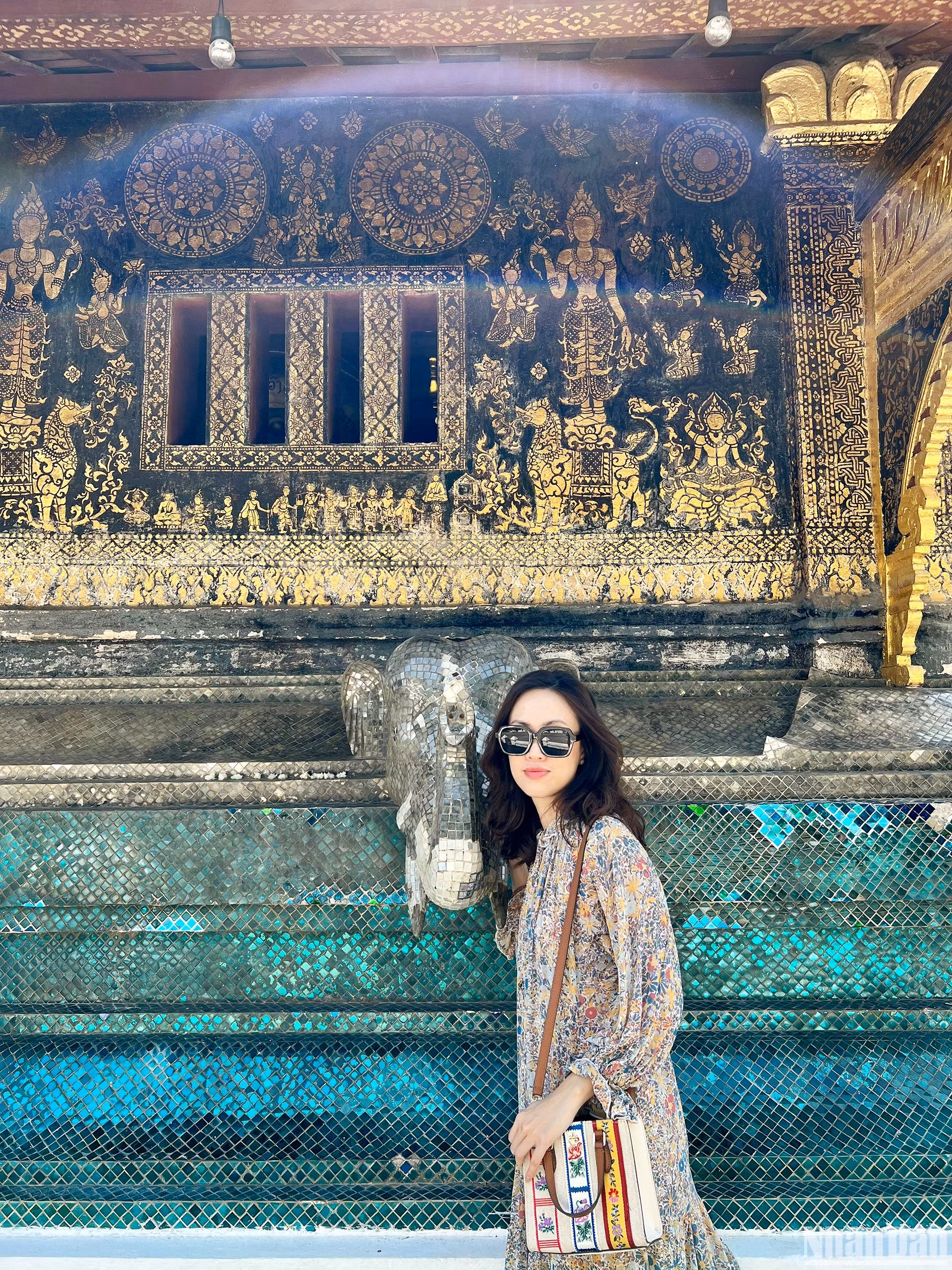 Du khách tranh thủ lưu lại những chi tiết, họa tiết đặc sắc được trang trí tinh tế trên những bức tường của Wat Xiengthong. (Ảnh: TRỊNH DŨNG)