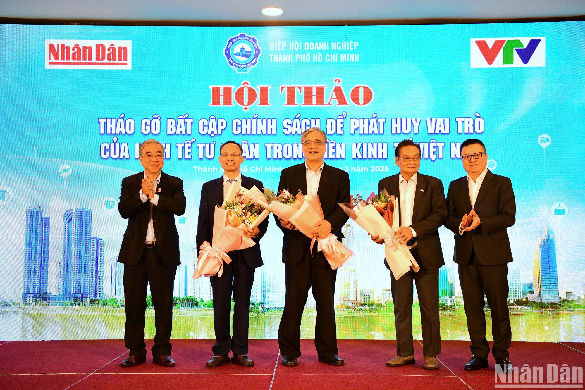Tổng Biên tập Báo Nhân Dân Lê Quốc Minh và Chủ tịch Hiệp hội Doanh nghiệp Thành phố Hồ Chí Minh Nguyễn Ngọc Hòa tặng hoa cảm ơn các chuyên gia tham dự hội thảo. (Ảnh: THẾ DƯƠNG)