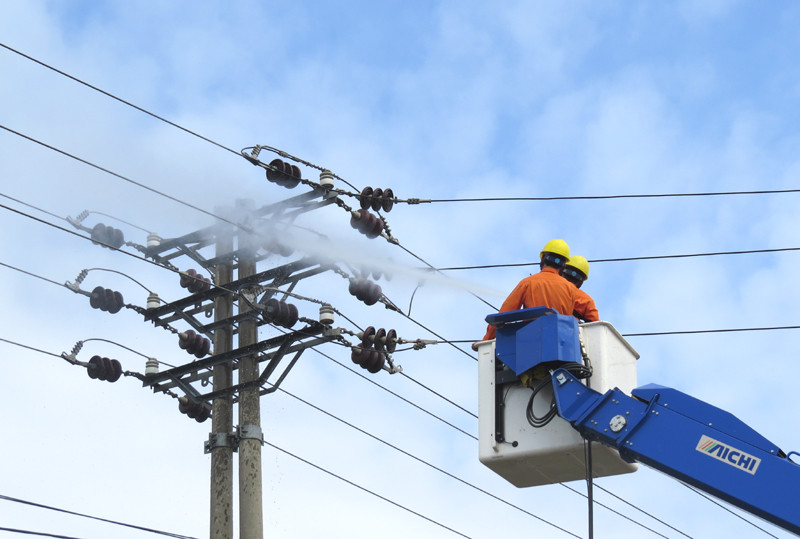 Công nhân điện lực Quảng Ninh rửa sứ trên đường dây mang điện.