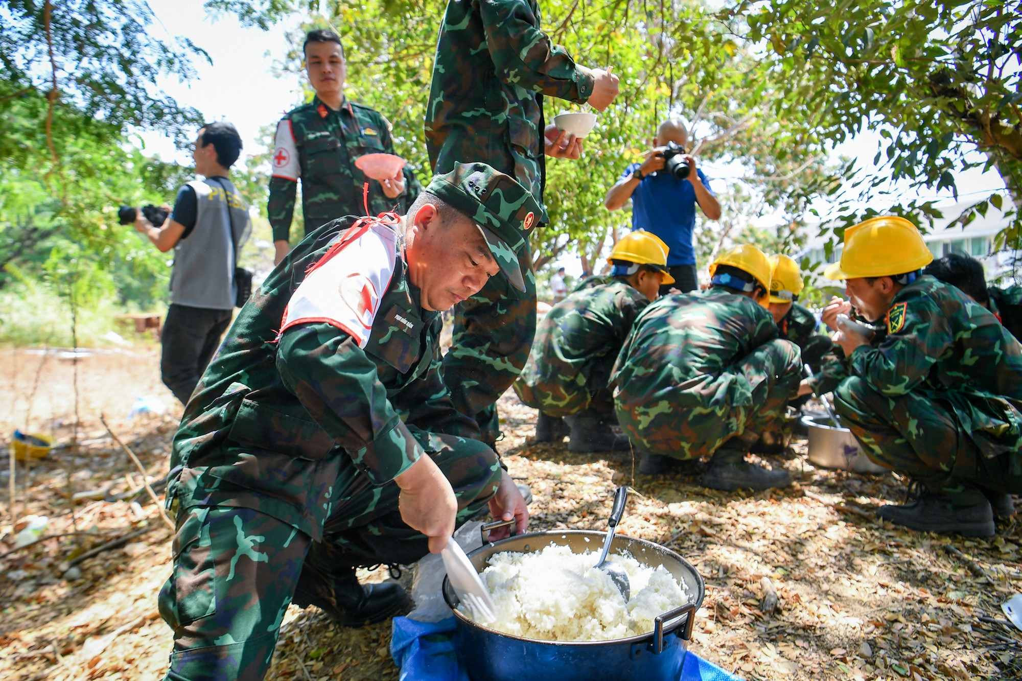 Dưới cái nắng lên tới 40 độ C tại Nayipydaw (Myanmar), lực lượng cứu nạn, cứu hộ Quân đội nhân dân Việt Nam tranh thủ ăn cơm để chuẩn bị vào ca làm việc buổi chiều.