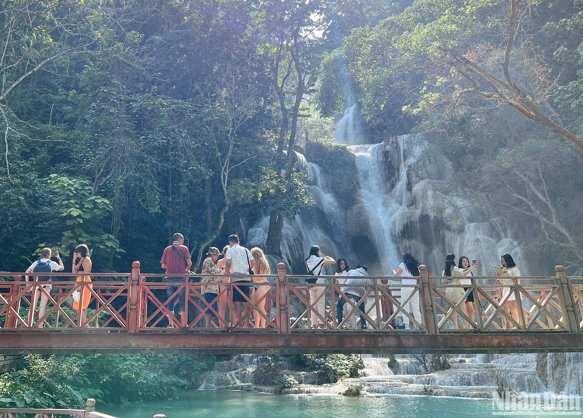 Du khách thích thú chiêm ngưỡng thác Kuangsi với màu nước xanh như ngọc. (Ảnh: TRỊNH DŨNG)