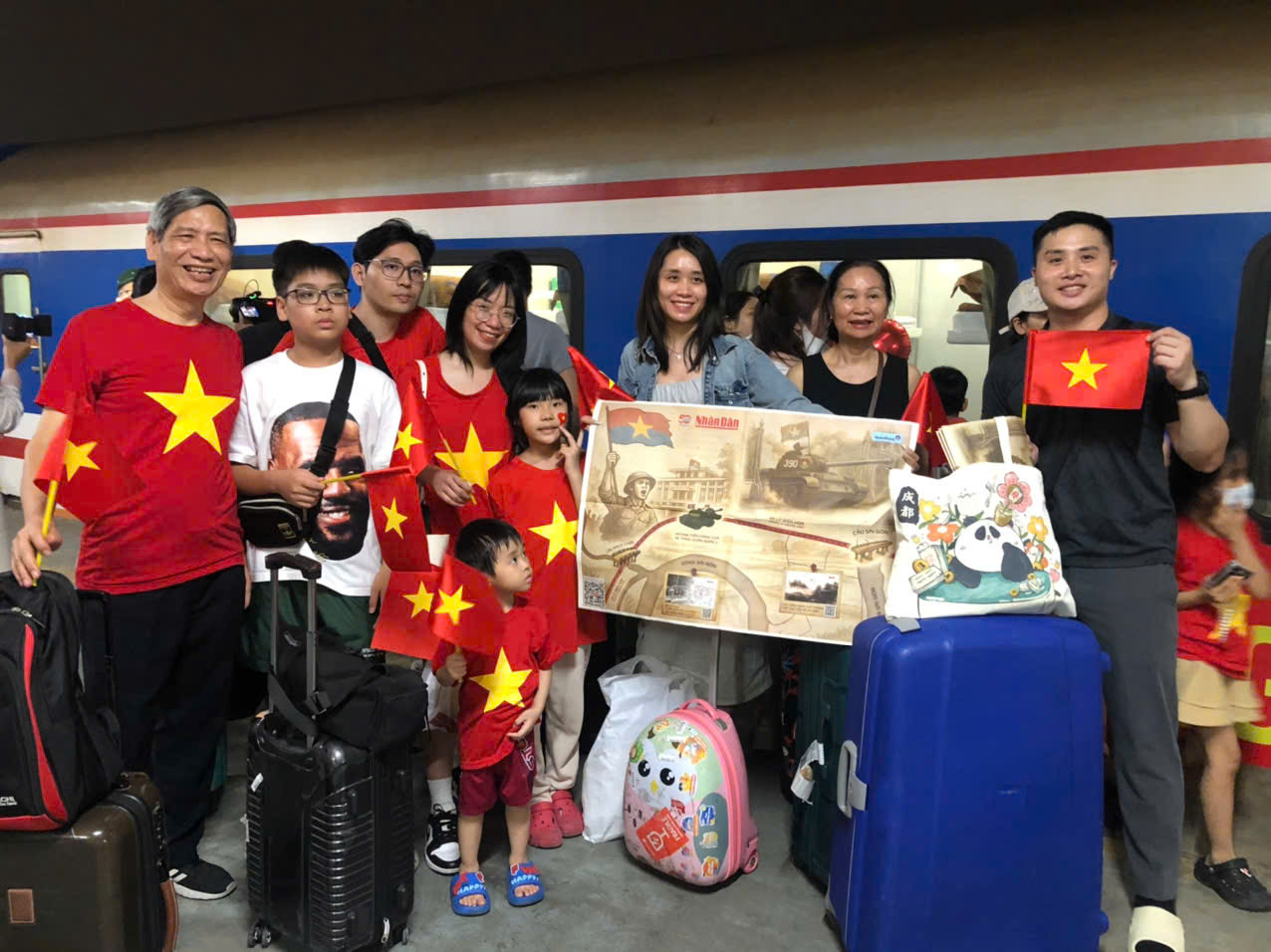 Ông Đinh Văn Là (bìa trái), quận Hai Bà Trưng, Hà Nội, cùng đại gia đình trên tay phụ san đặc biệt của Báo Nhân Dân trước giờ lên tàu. (Ảnh: TUẤN ANH) Ông Đinh Văn Là (bìa trái), quận Hai Bà Trưng, Hà Nội, cùng đại gia đình trên tay phụ san đặc biệt của Báo Nhân Dân trước giờ lên tàu. (Ảnh: TUẤN ANH)
