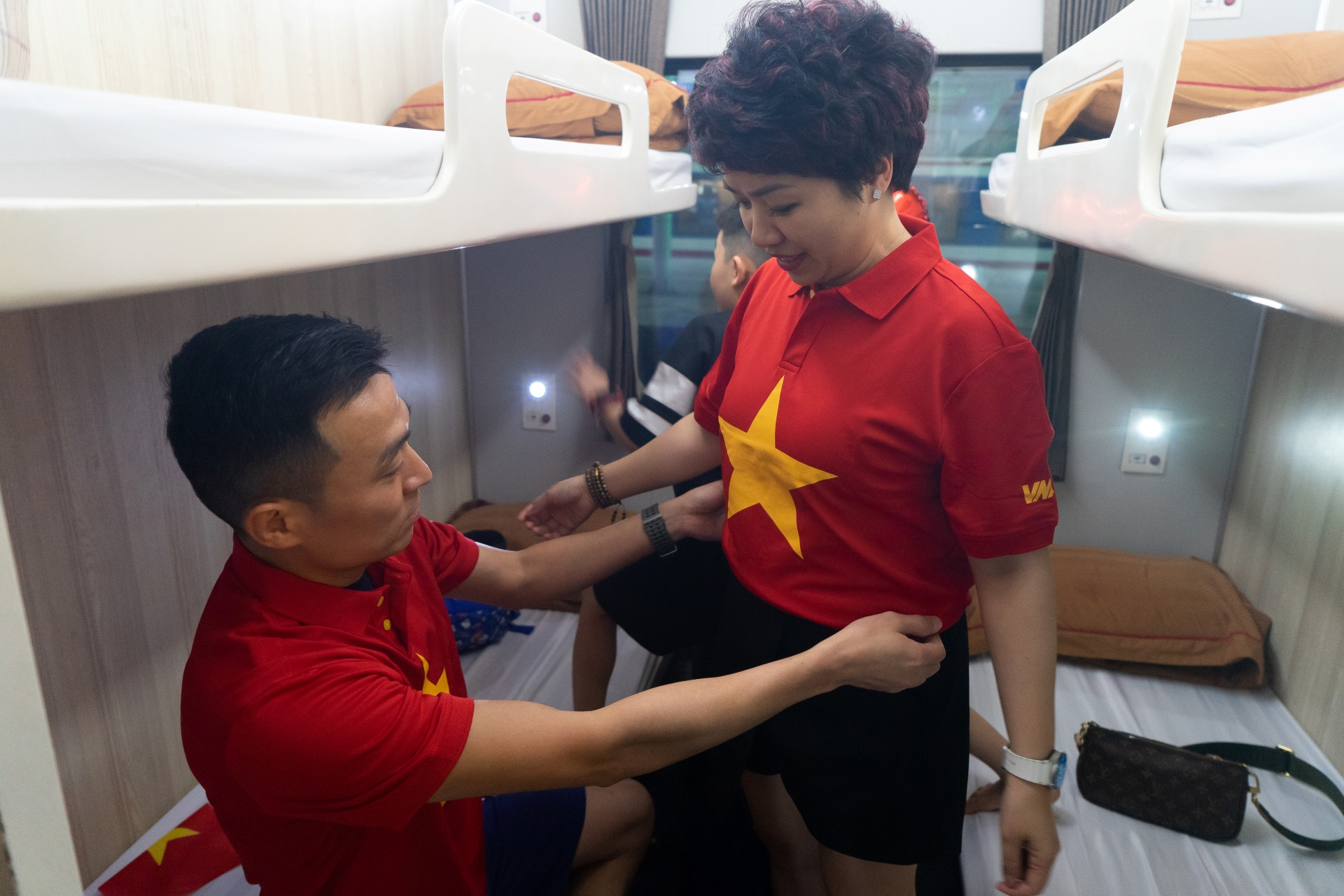 Mỗi hành khách đều nhận được những chiếc áo cờ đỏ sao vàng trên chuyến tàu Thống nhất. (Ảnh: TRUNG HƯNG) Mỗi hành khách đều nhận được những chiếc áo cờ đỏ sao vàng trên chuyến tàu Thống nhất. (Ảnh: TRUNG HƯNG)
