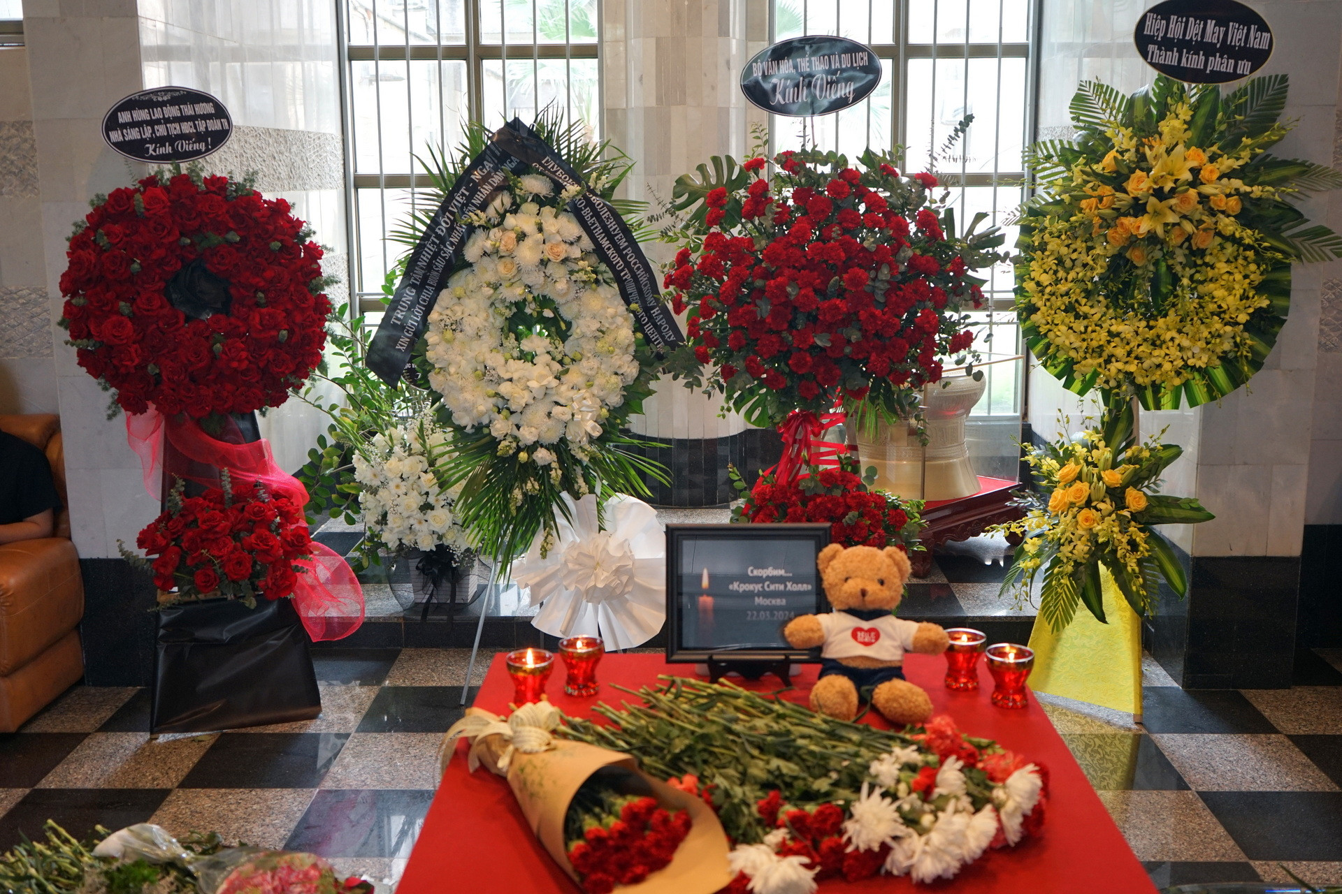 Nến, hoa tươi và gấu bông được đặt tại trụ sở Đại sứ quán Liên bang Nga để tưởng nhớ các nạn nhân. (Ảnh: TRUNG HƯNG)