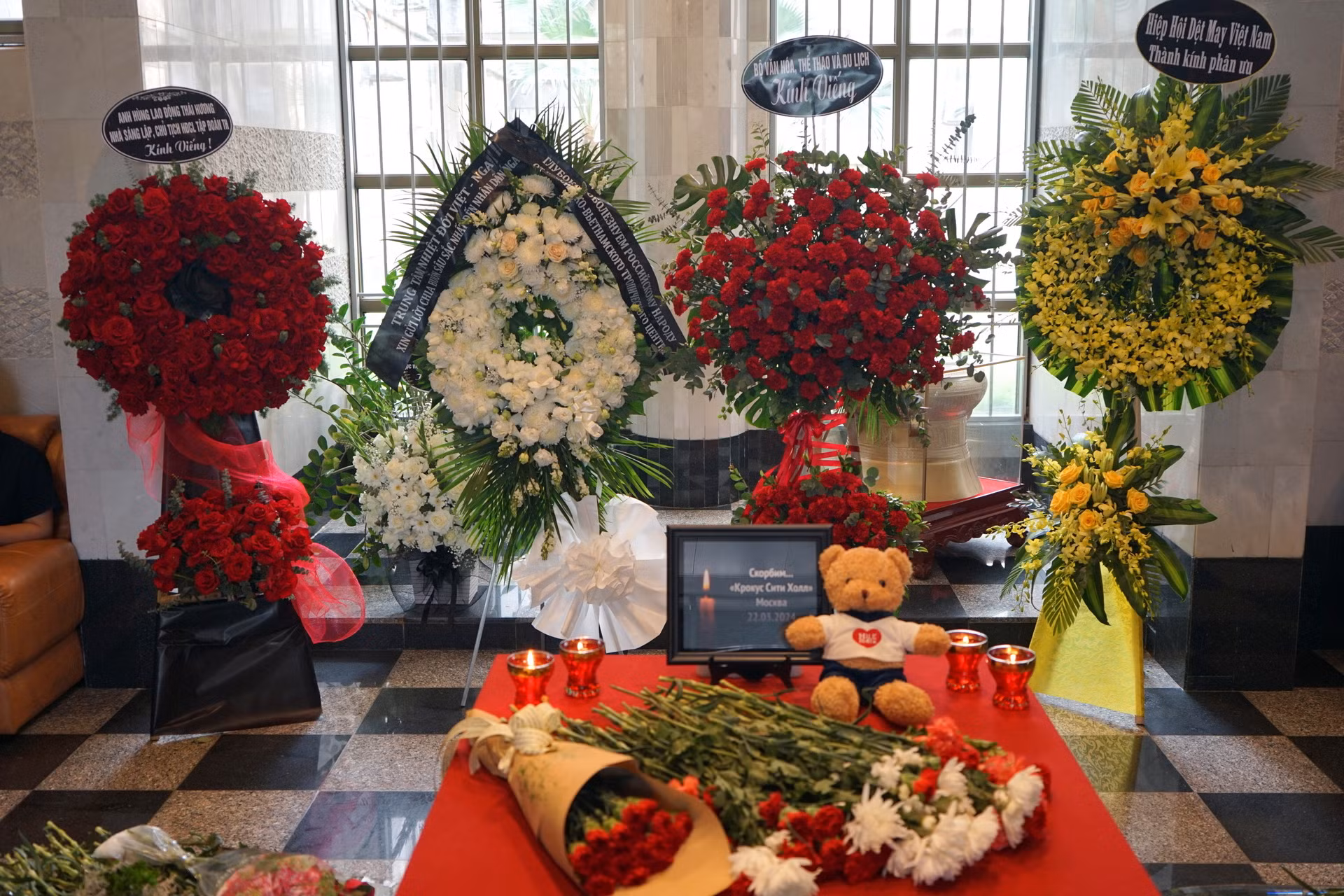 Nến, hoa tươi và gấu bông được đặt tại trụ sở Đại sứ quán Liên bang Nga để tưởng nhớ các nạn nhân. (Ảnh: TRUNG HƯNG)