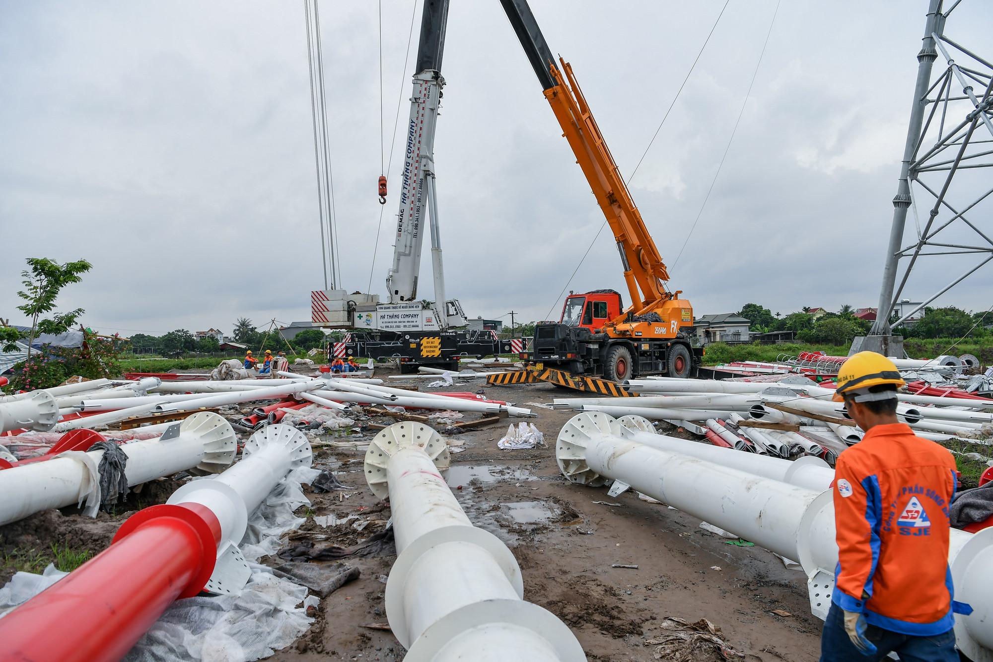 Các cấu kiện khổng lồ được tổ hợp trước dưới mặt đất trước khi được cần cẩu hạng nặng đưa lên cao để lắp đặt trên cột. (Ảnh: THÀNH ĐẠT)