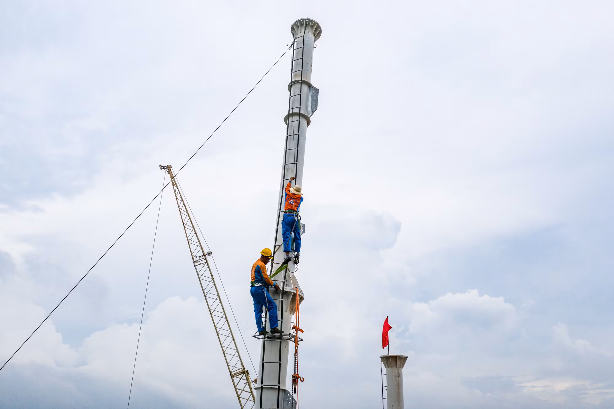 Ở các vị trí cao nhất mà cẩu đã tới giới hạn, công nhân phải sử dụng thêm thang dây để di chuyển và lắp đặt các cấu kiện trên điểm cao. (Ảnh: THÀNH ĐẠT) Ở các vị trí cao nhất mà cẩu đã tới giới hạn, công nhân phải sử dụng thêm thang dây để di chuyển và lắp đặt các cấu kiện trên điểm cao. (Ảnh: THÀNH ĐẠT)