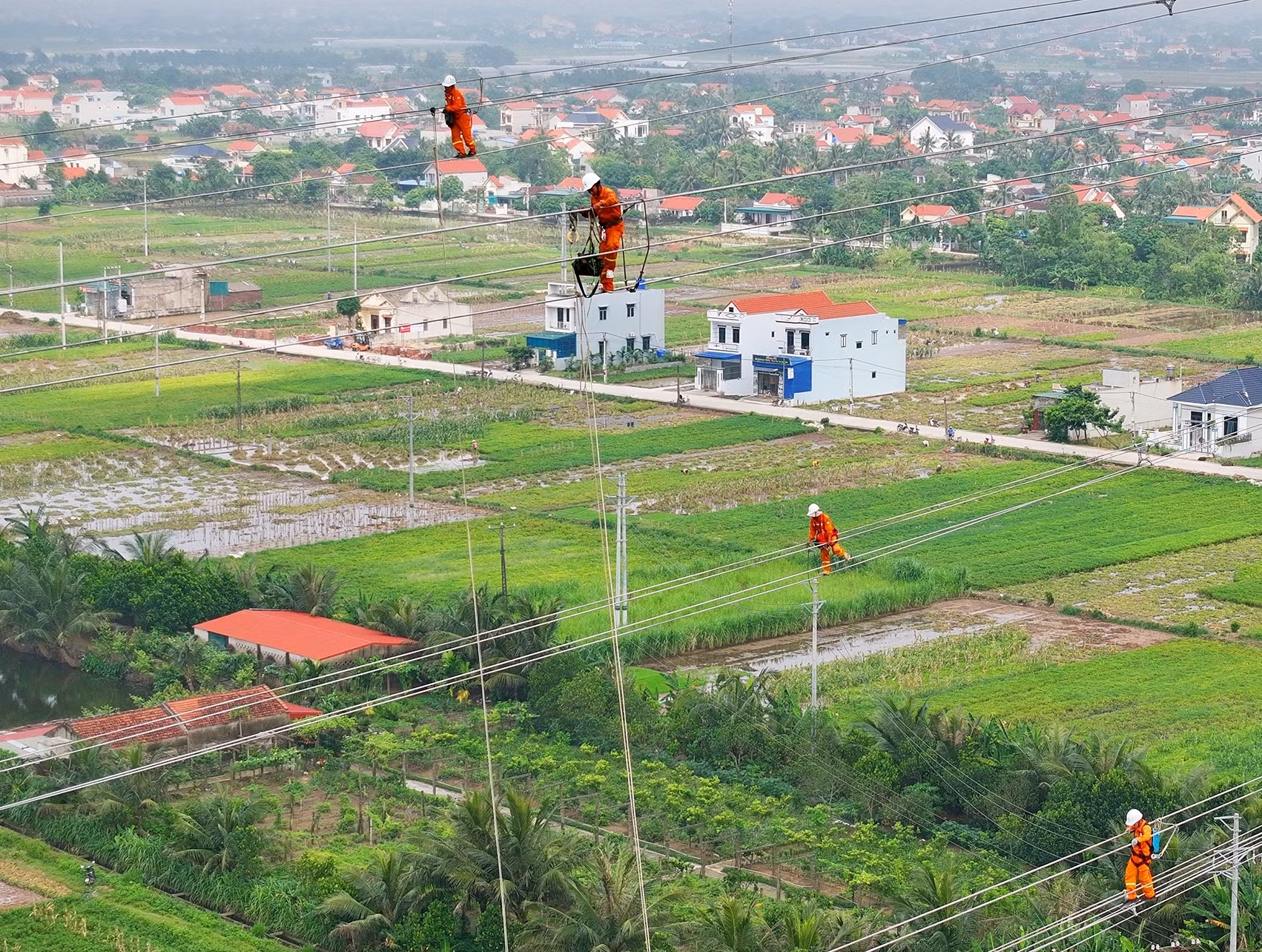 Các kỹ sư và công nhân ngành điện treo mình thi công trên cao. (Ảnh: TUẤN HUY)