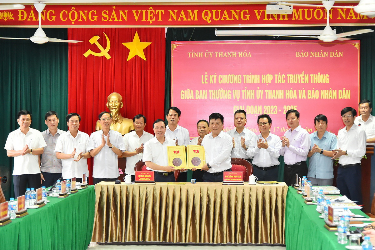 Phó Tổng Biên tập Báo Nhân Dân Quế Đình Nguyên và Phó Bí thư Thường trực Tỉnh ủy Thanh Hoá Lại Thế Nguyên trao nhau bản thỏa thuận hợp tác truyền thông giữa 2 cơ quan trước sự chứng kiến của lãnh đạo 2 đơn vị.