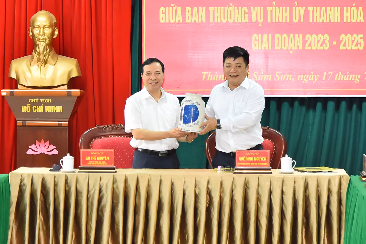 Phó Tổng Biên tập Báo Nhân Dân Quế Đình Nguyên trao quà lưu niệm tặng Phó Bí thư Thường trực Tỉnh ủy Thanh Hóa Lại Thế Nguyên sau lễ ký kết.