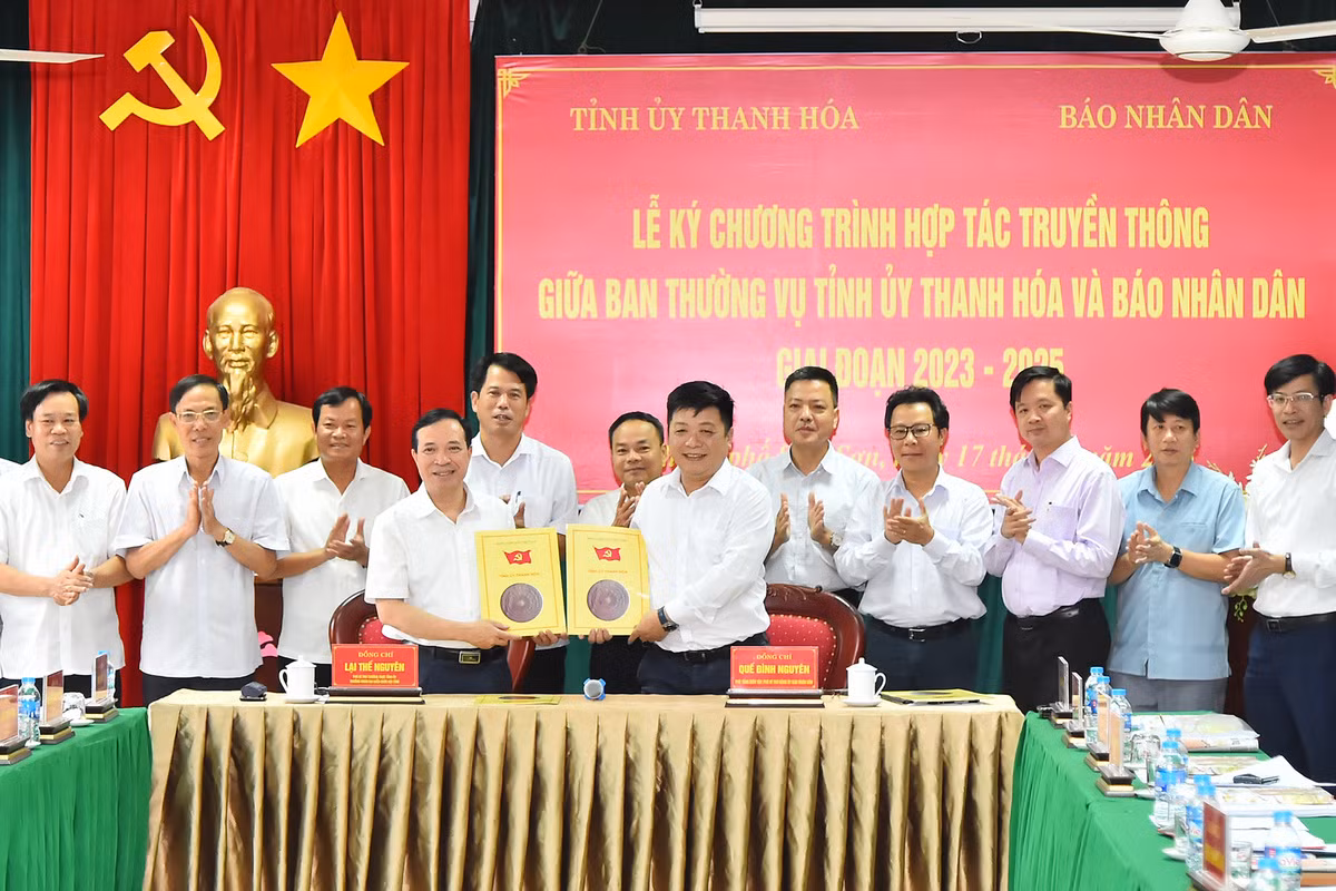 Phó Tổng Biên tập Báo Nhân Dân Quế Đình Nguyên và Phó Bí thư Thường trực Tỉnh ủy Thanh Hóa Lại Thế Nguyên trao nhau bản thỏa thuận hợp tác truyền thông.