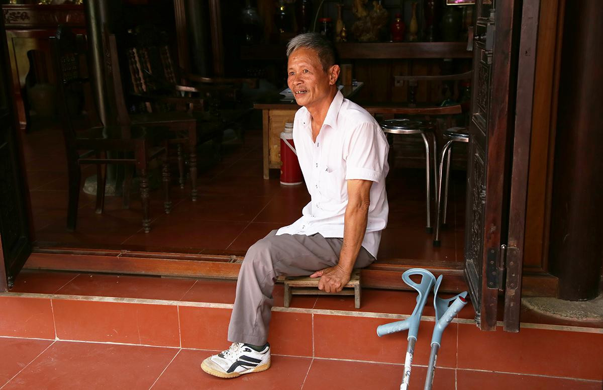 Cặp ghế gỗ thấp và đôi nạng gỗ giúp ông Tùng di chuyển hằng ngày.