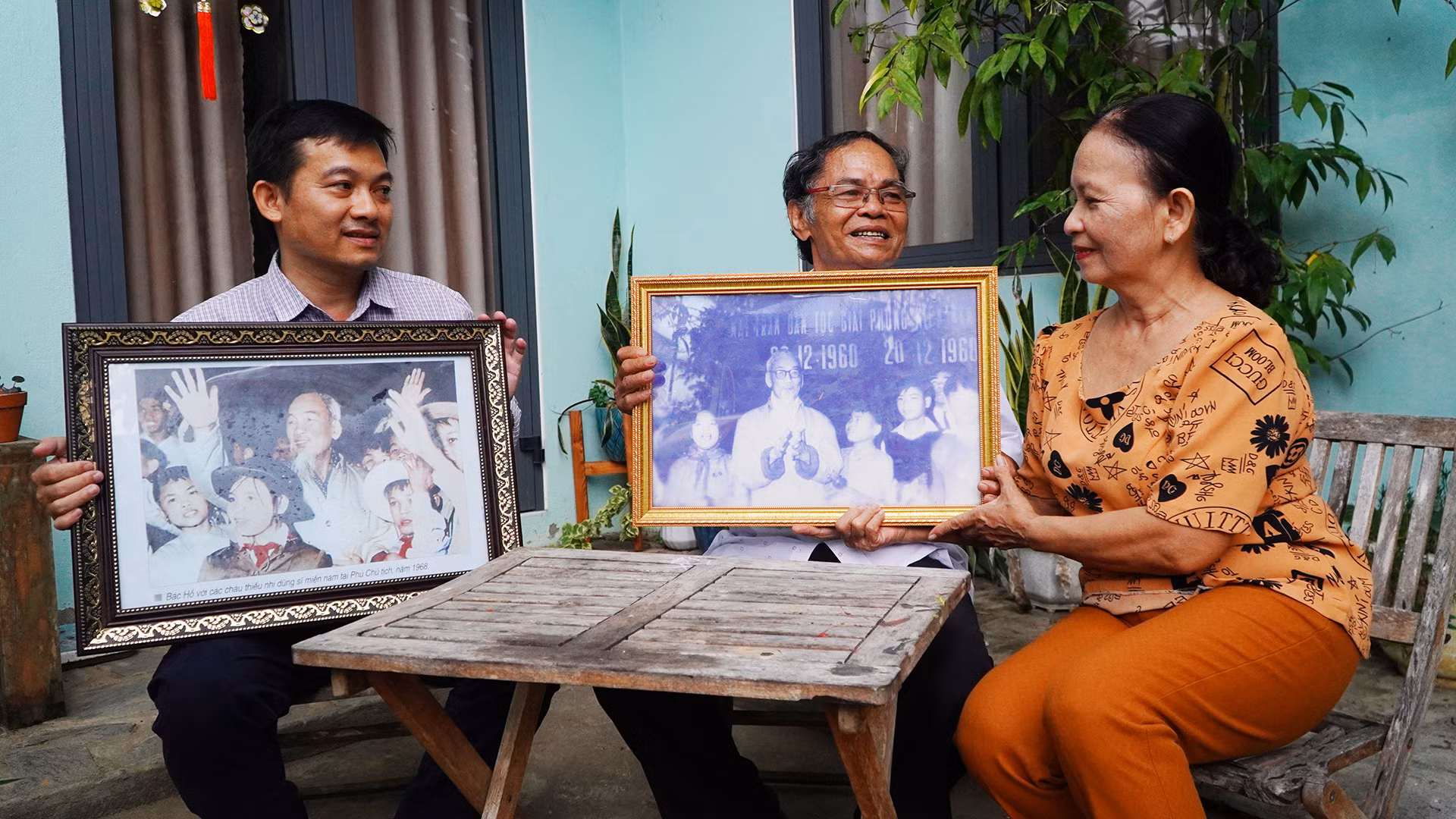 Ông Hồ Ngọc Biên (ở giữa) cùng vợ và người con trai thứ 2 bên những tấm hình vinh dự được chụp chung với Bác Hồ.