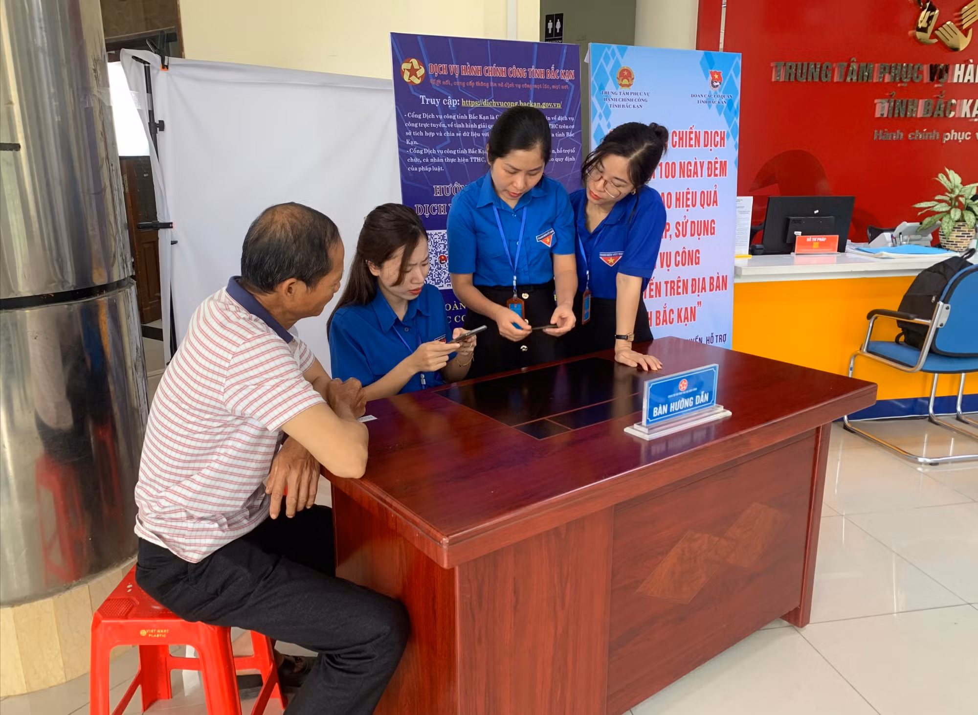 Đoàn viên, thanh niên hướng dẫn người dân sử dụng dịch vụ công tại Trung tâm hành chính công của tỉnh. (Ảnh: THU TRANG)
