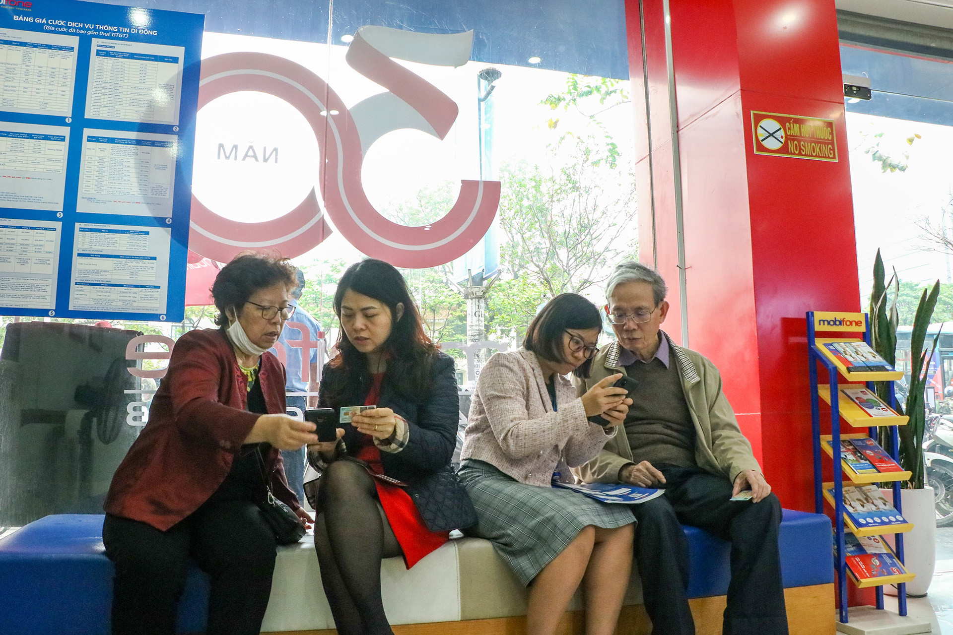 Do lượng khách đông, quầy tiếp khách bị quá tải nên nhân viên phòng giao dịch chủ động hướng dẫn người dân tại ghế chờ.