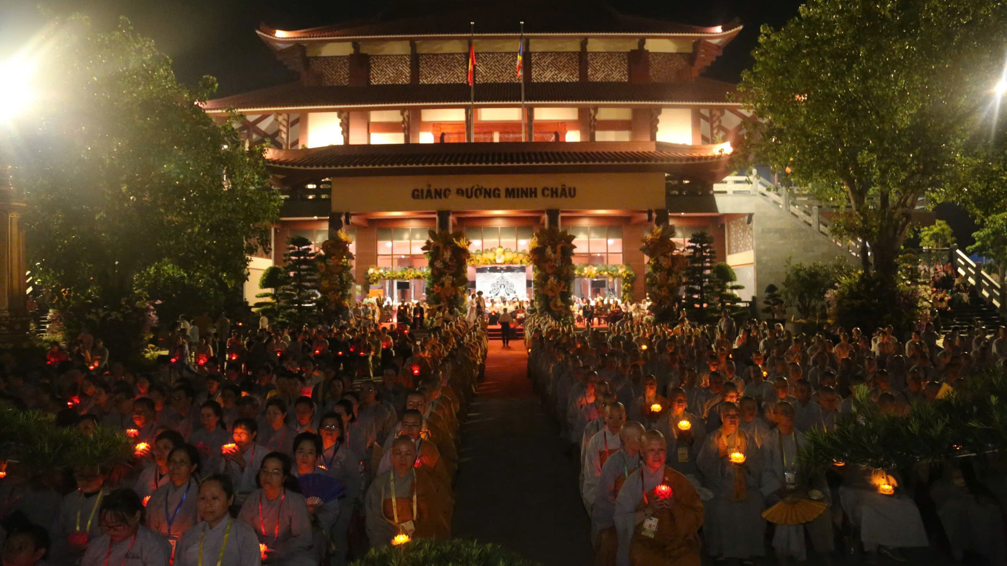 Tại Giảng đường Minh Châu, các tăng ni, Phật tử cùng thắp sáng ngọn hoa đăng trên tay.