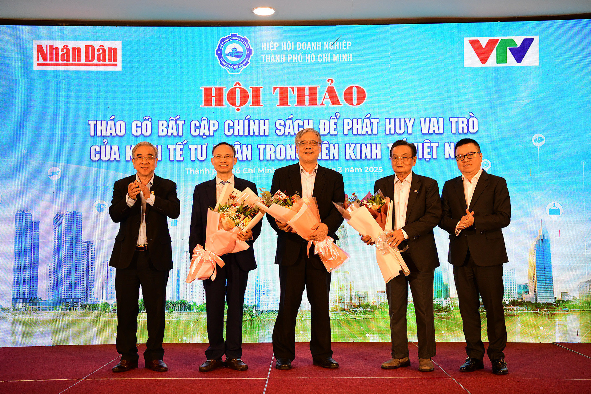 Ban Tổ chức tặng hoa kỷ niệm tới các chuyên gia kinh tế tham dự hội thảo.