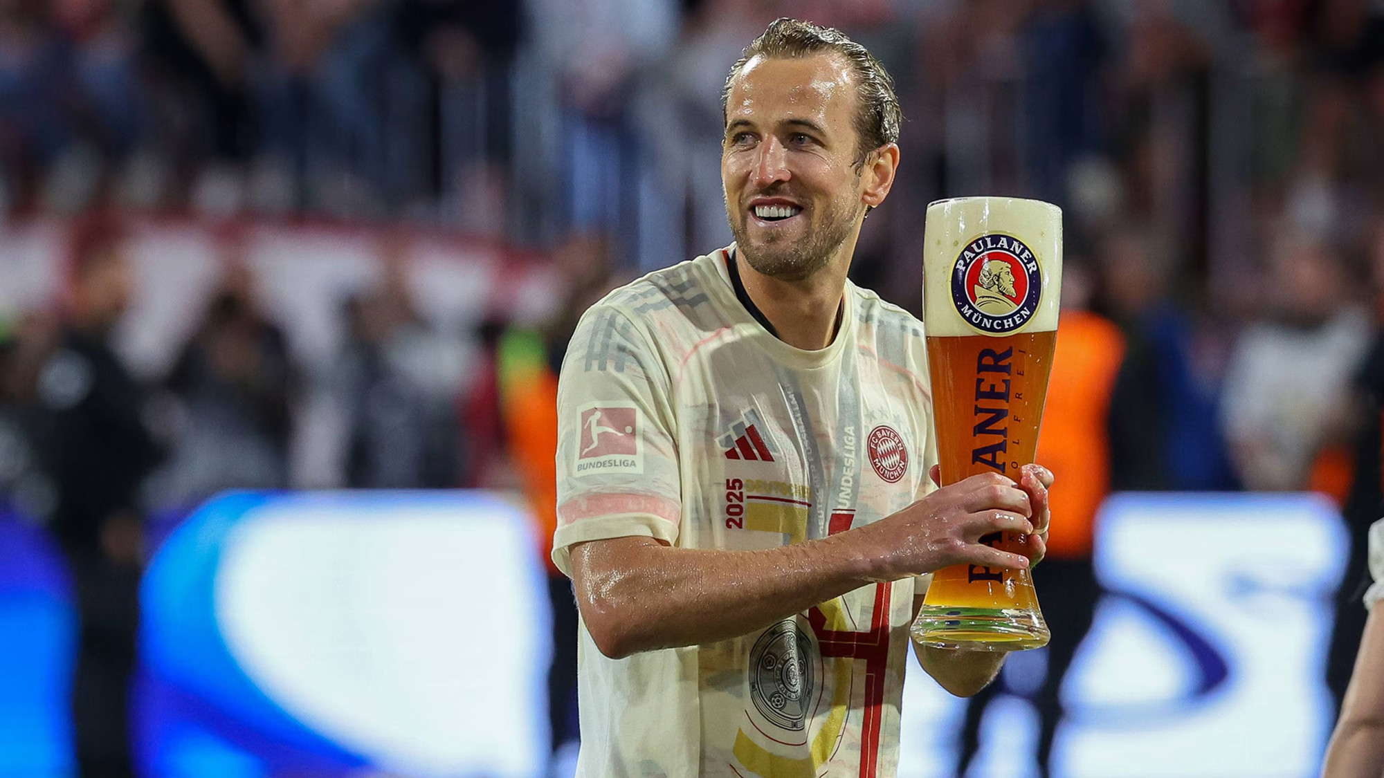 Harry Kane rạng rỡ nâng cốc bia khổng lồ trong màn “tắm bia” truyền thống của Bayern Munich - khoảnh khắc đánh dấu danh hiệu đầu tiên sau 16 năm chờ đợi của tiền đạo người Anh. (Ảnh: Bayern FC) Harry Kane rạng rỡ nâng cốc bia khổng lồ trong màn “tắm bia” truyền thống của Bayern Munich - khoảnh khắc đánh dấu danh hiệu đầu tiên sau 16 năm chờ đợi của tiền đạo người Anh. (Ảnh: Bayern FC)