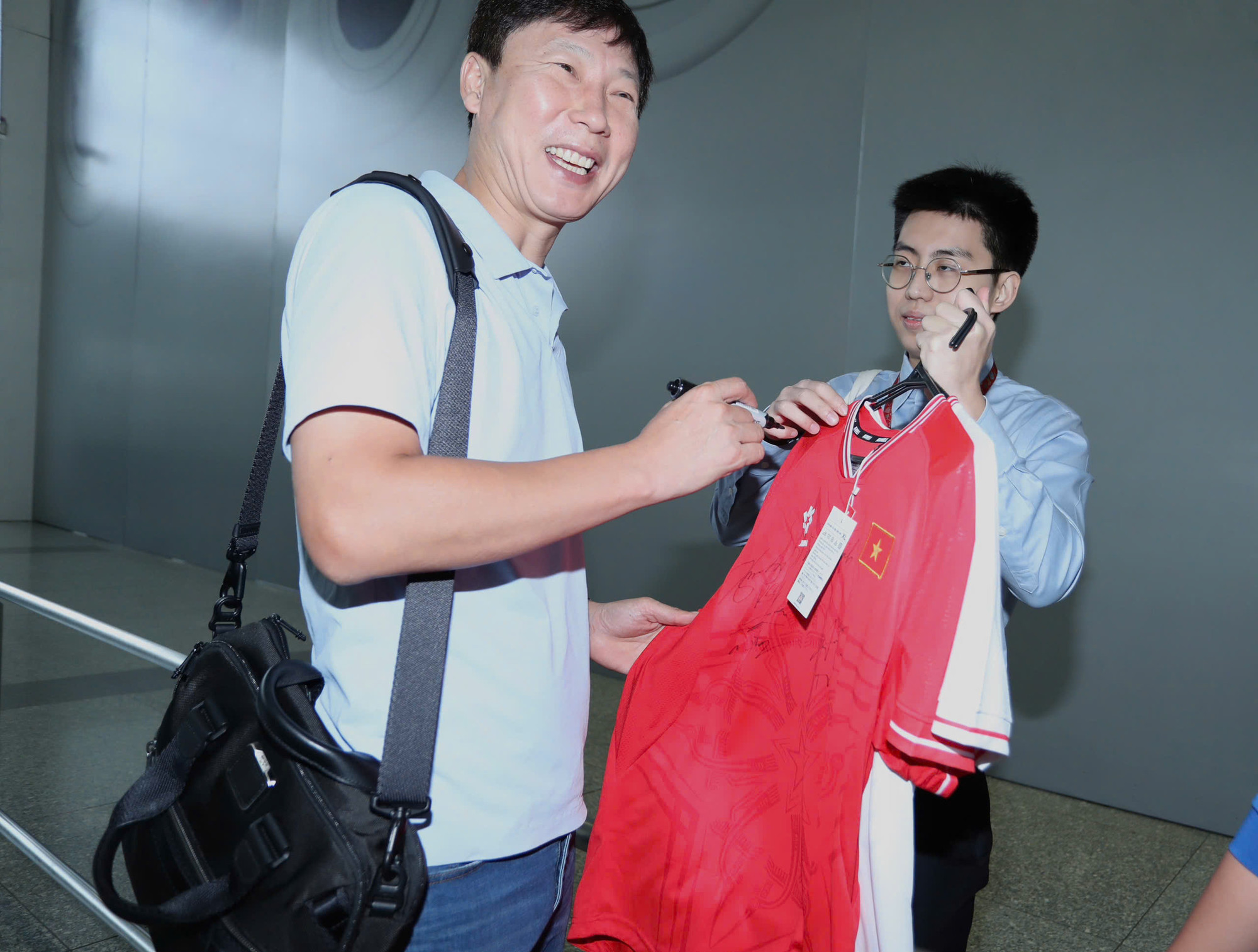 Thầy Kim Sang-sik vui vẻ ký áo tặng người hâm mộ.