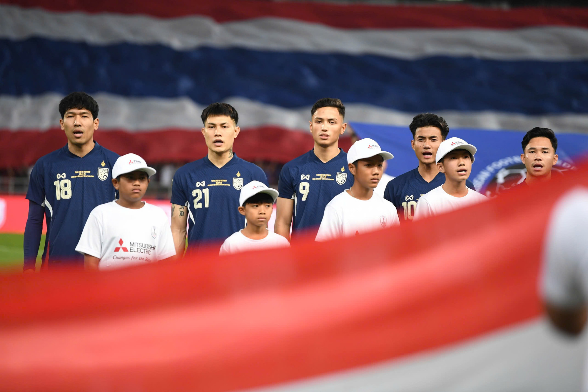 Các thành viên đội tuyển Thái Lan thực hiện nghi thức chào cờ và hát quốc ca.