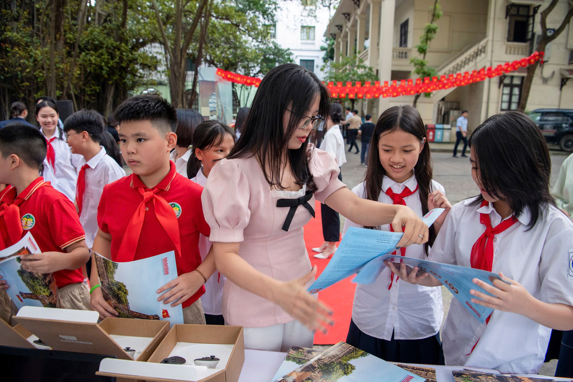 Ban tổ chức phát cho mỗi em học sinh 1 bản phụ san Báo Nhân Dân để có thể về nhà cắt ghép mô hình Cột cờ Hà Nội.