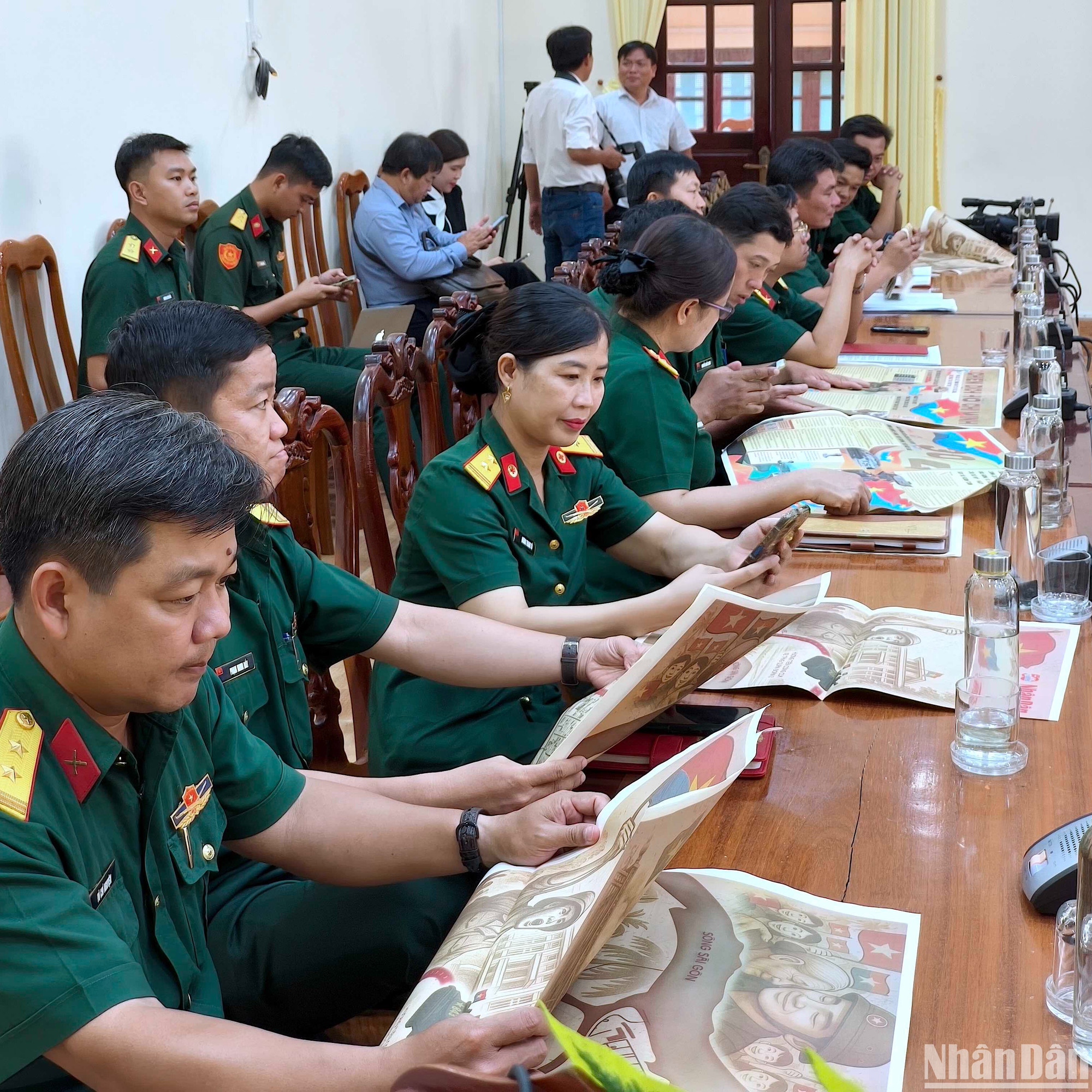Cán bộ, chiến sĩ Bộ Chỉ huy Quân sự tỉnh Cà Mau thưởng thức Ấn phẩm phụ san đặc biệt của Báo Nhân Dân kỷ niệm 50 năm Ngày Giải phóng miền nam, thống nhất đất nước.