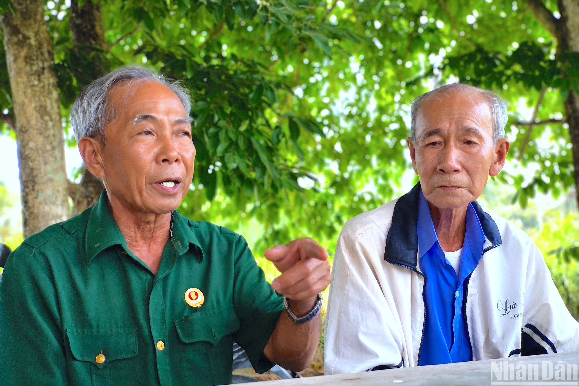 Cựu chiến binh Dương Văn Bé (bìa trái) thuật lại tấm gương người lính Phan Văn Thuấn năm xưa kiên cường chiến đấu chống giặc, dù thân mình đầy vết thương.