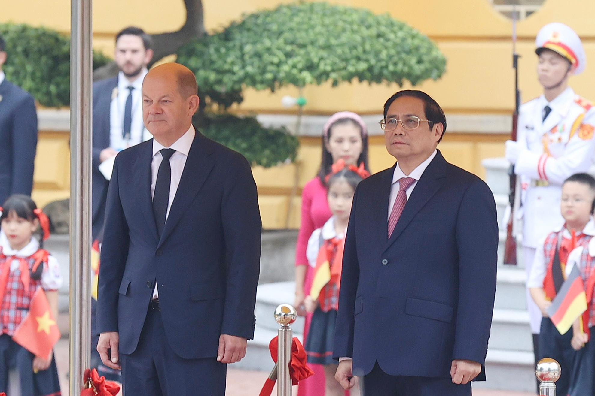 Thủ tướng Phạm Minh Chính và Thủ tướng Olaf Scholz thực hiện nghi thức chào cờ, hát Quốc ca hai nước tại lễ đón. Thủ tướng Phạm Minh Chính và Thủ tướng Olaf Scholz thực hiện nghi thức chào cờ, hát Quốc ca hai nước tại lễ đón.