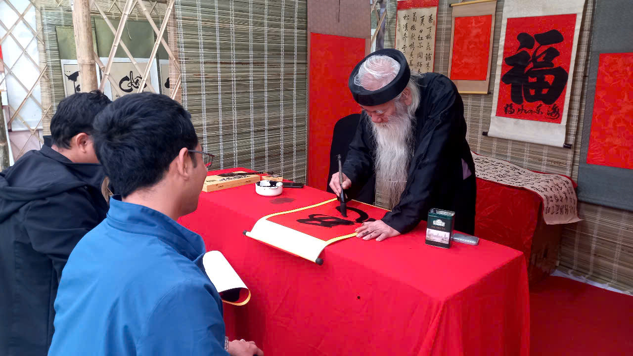 Một "ông đồ" cao niên say sưa với nét bút.