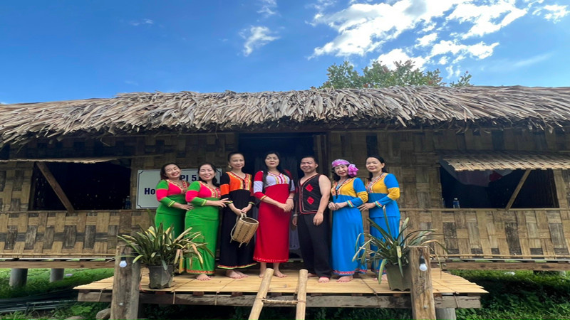 Du khách mặc trang phục của đồng bào thiểu số Raglai và chụp ảnh lưu niệm tại căn nhà sàn truyền thống của bà con nơi đây.