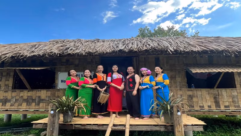 Du khách mặc trang phục của đồng bào thiểu số Raglai và chụp ảnh lưu niệm tại căn nhà sàn truyền thống của bà con nơi đây.