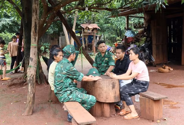 Lực lượng biên phòng thăm hỏi, động viên gia đình nạn nhân vừa được hỗ trợ đưa từ Campuchia về địa phương. (Ảnh: TTXVN)