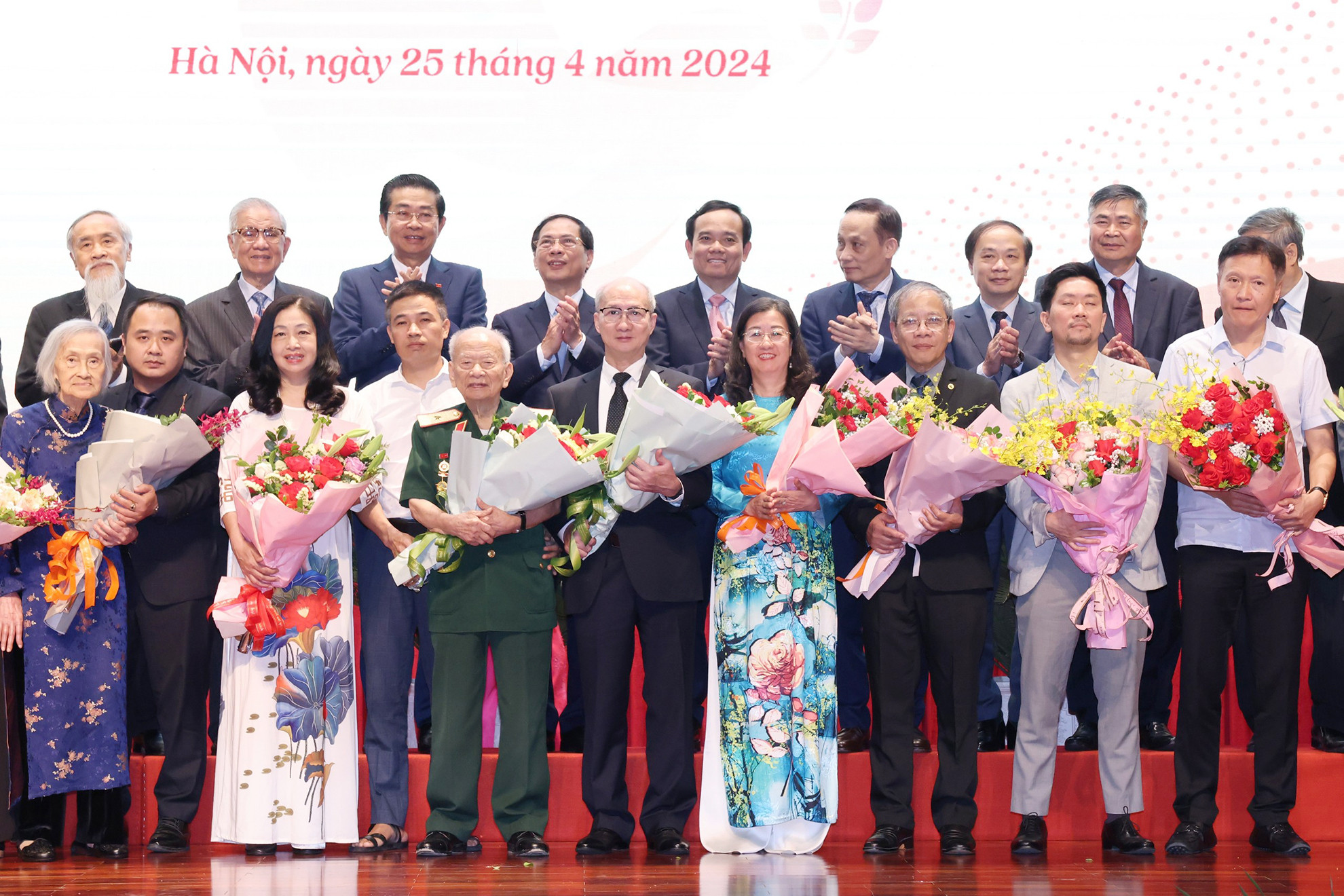 Trưởng Ban Đối ngoại Trung ương Lê Hoài Trung và Phó Thủ tướng Trần Lưu Quang tặng hoa, chúc mừng đại diện gia đình cán bộ tham gia phục vụ Hội nghị Geneve tại Lễ kỷ niệm.