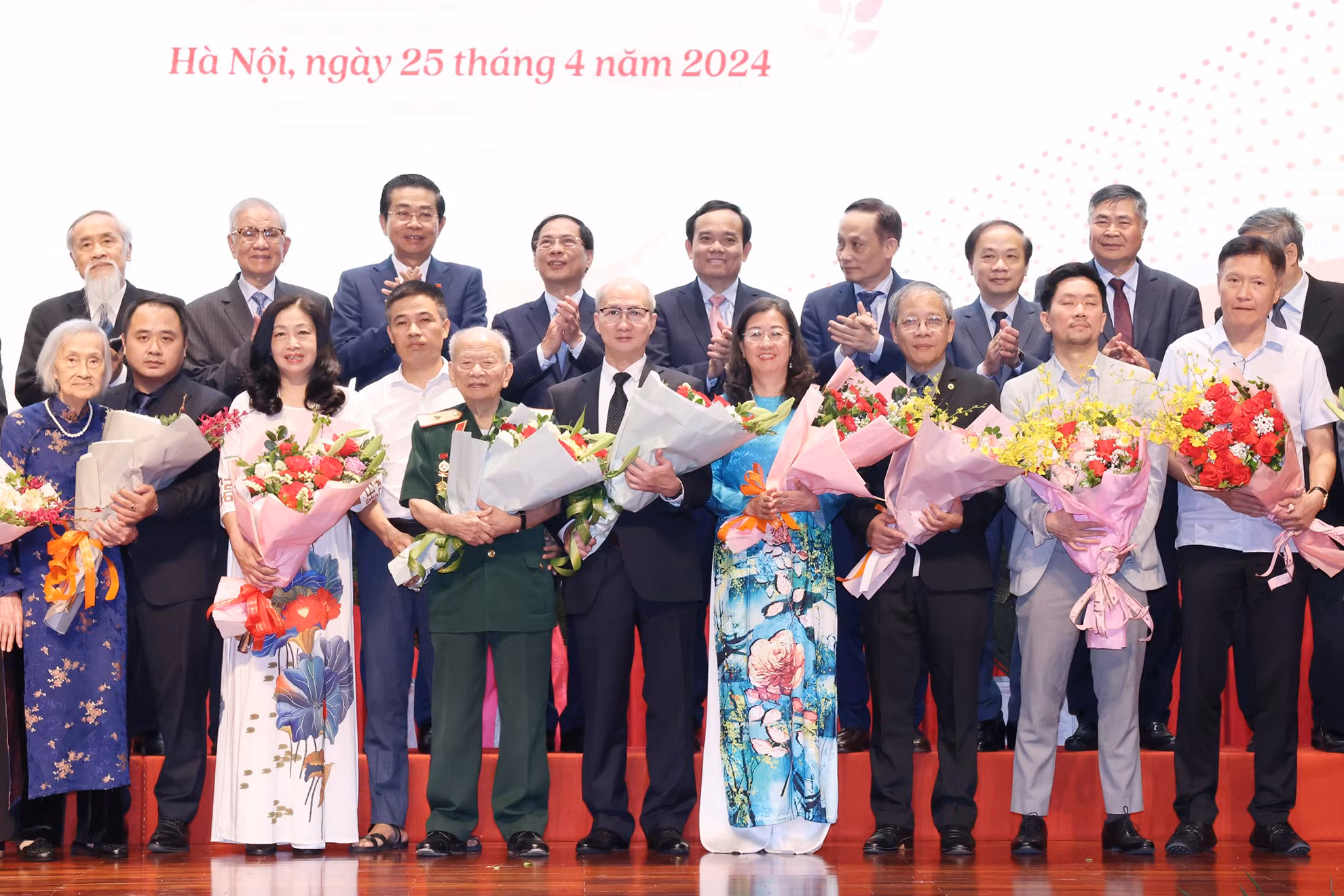 Trưởng Ban Đối ngoại Trung ương Lê Hoài Trung và Phó Thủ tướng Trần Lưu Quang tặng hoa, chúc mừng đại diện gia đình cán bộ tham gia phục vụ Hội nghị Geneve tại Lễ kỷ niệm.