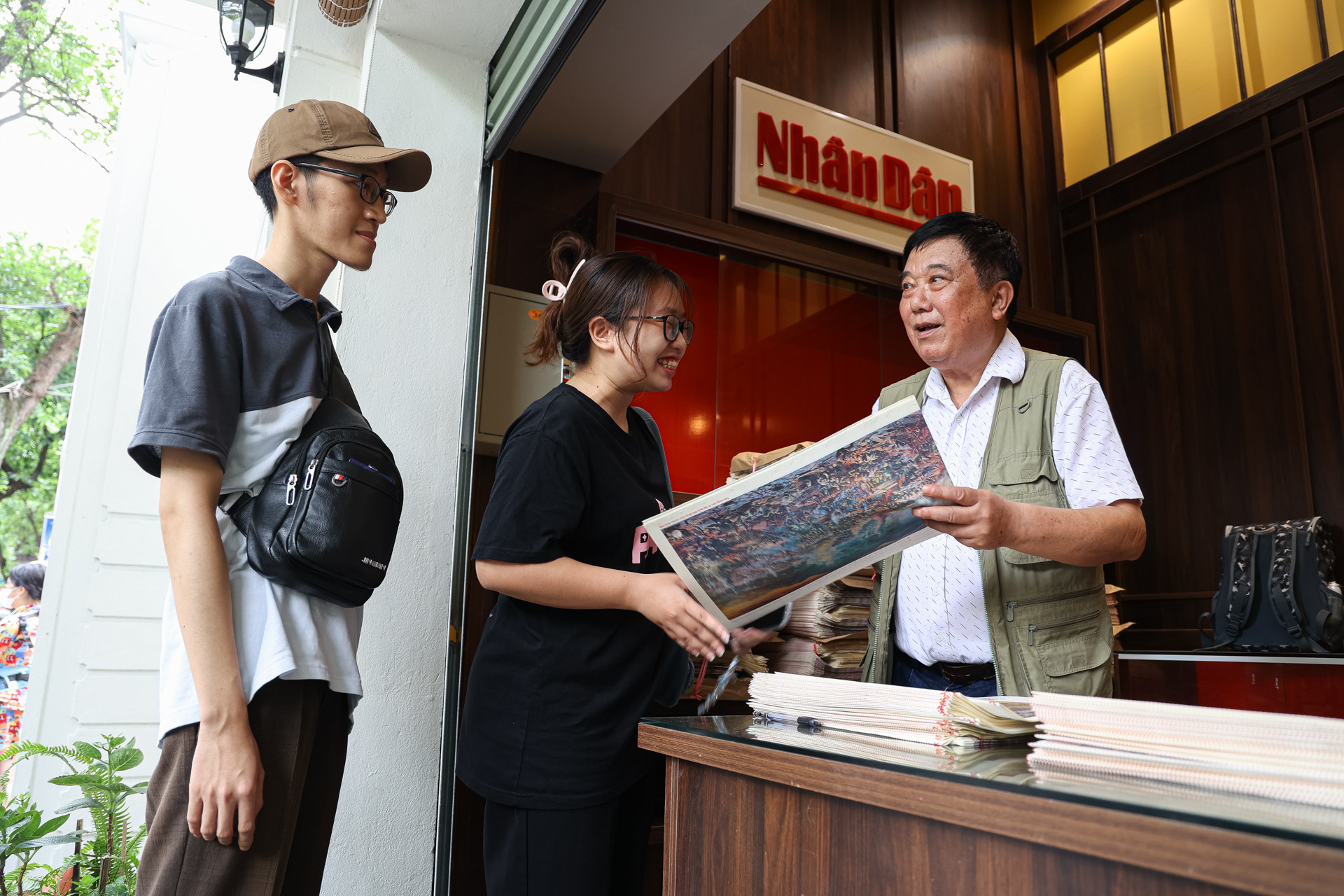 Họa sĩ Nguyễn Văn Mạc - “kiến trúc sư trưởng” của bức tranh tường panorama Chiến dịch Điện Biên Phủ ký tặng cho các độc giả.