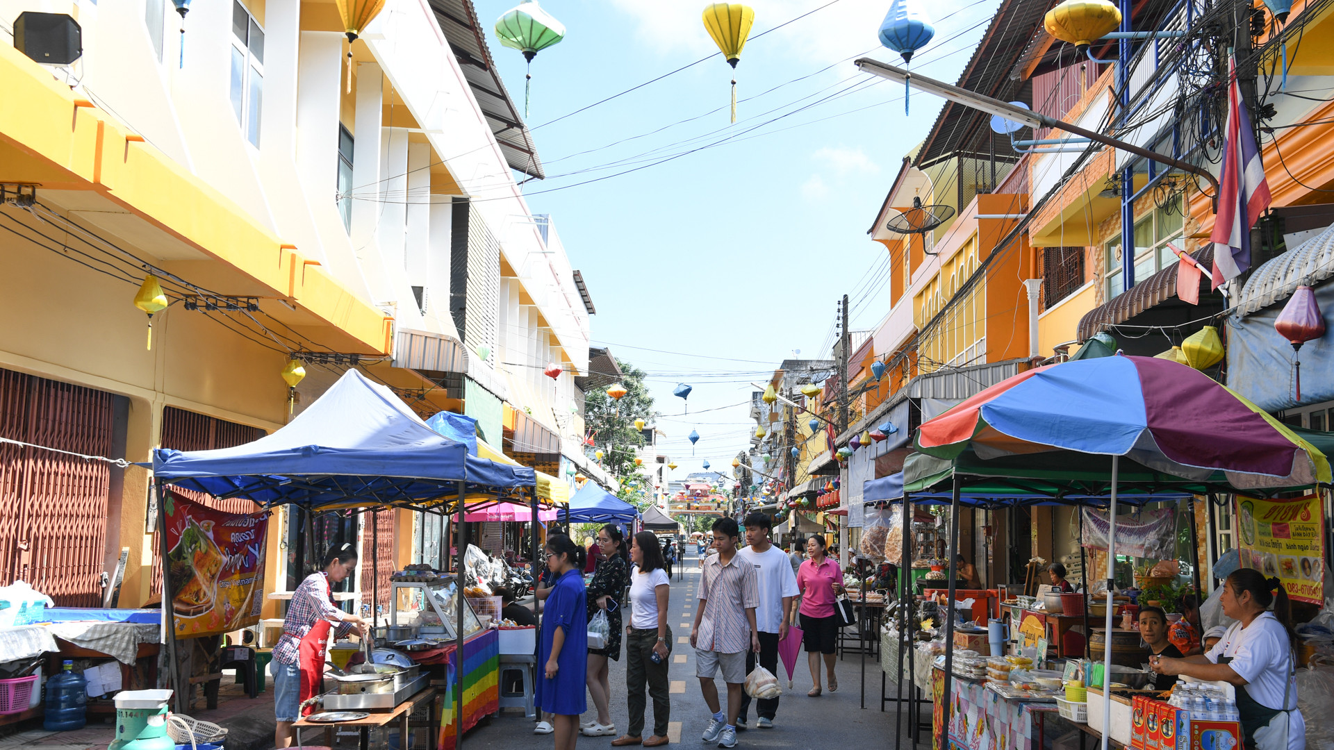 Các gia đình kiều bào, người Thái Lan và cả những du khách nước ngoài tản bộ dọc theo các gian hàng.