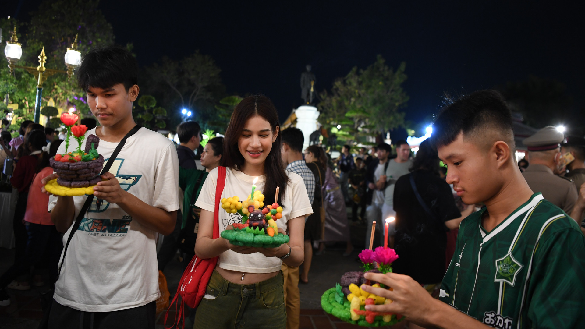 Các bạn trẻ cầm trong tay những chiếc bè “Krathong” được làm bằng bột gạo, dễ tan trong nước, thân thiện với môi trường.