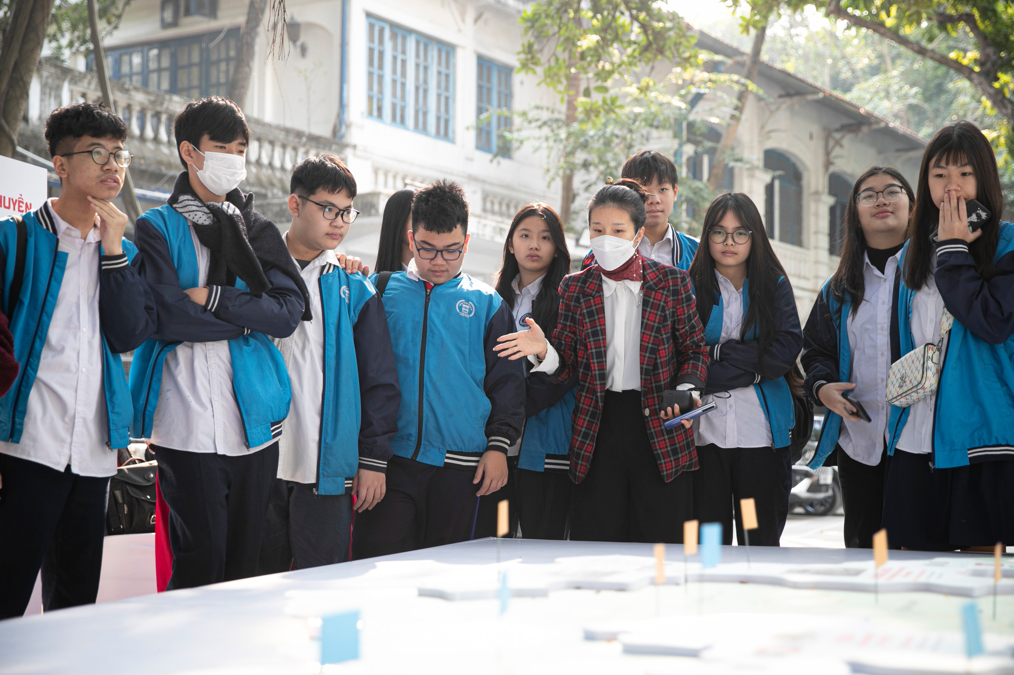 Phóng viên Báo Nhân Dân hướng dẫn cho các em học sinh trải nghiệm triển lãm. Phóng viên Báo Nhân Dân hướng dẫn cho các em học sinh trải nghiệm triển lãm.