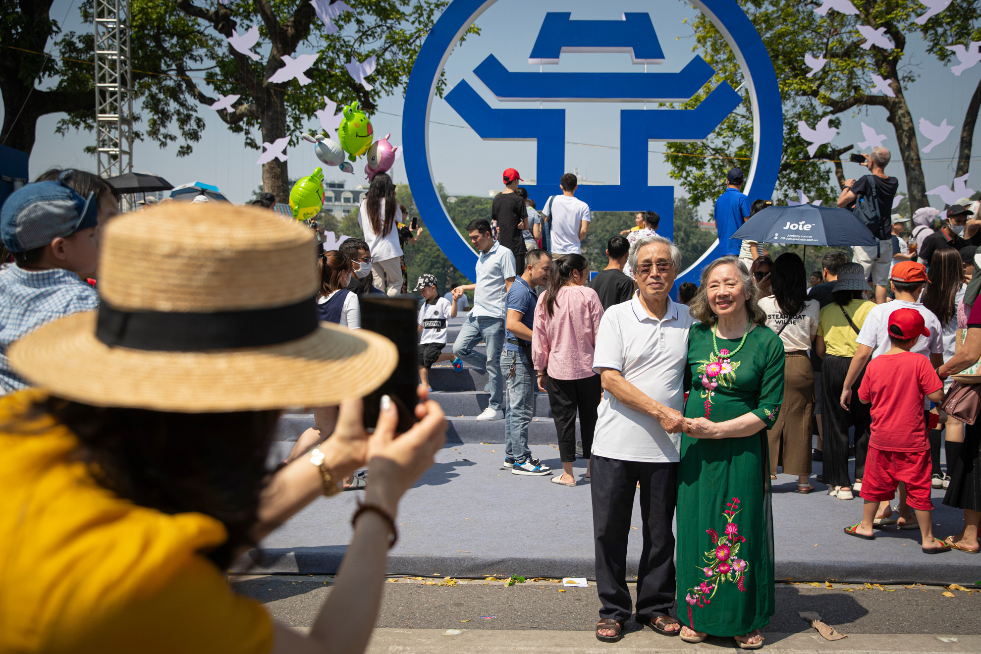 Người dân chụp ảnh lưu niệm với biểu tượng của Hà Nội tại khu vực trước tượng đài vua Lý Thái Tổ.