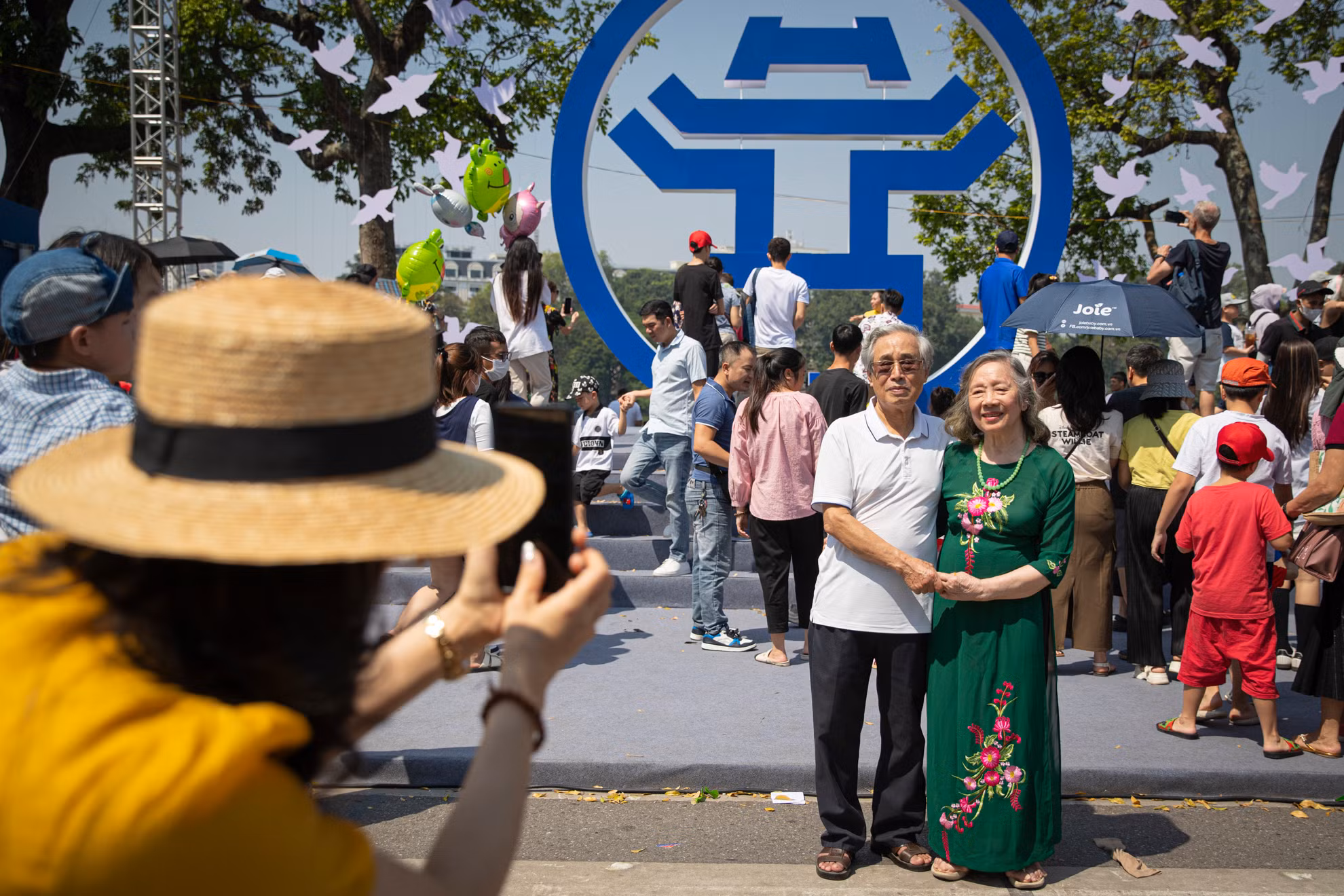 Người dân chụp ảnh lưu niệm với biểu tượng của Hà Nội tại khu vực trước tượng đài vua Lý Thái Tổ.