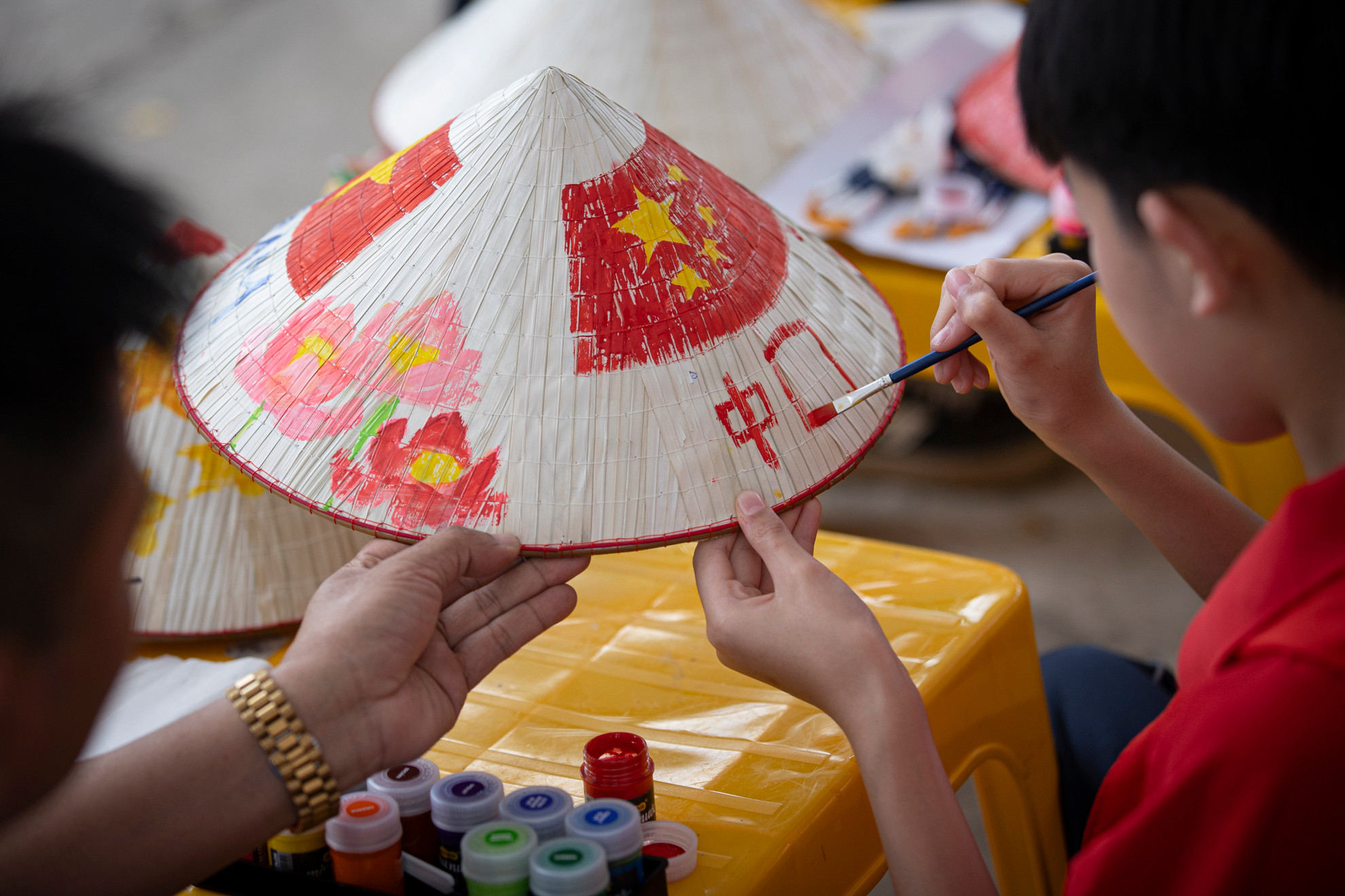 Một học sinh của đoàn Trung Quốc đang hoàn thành tác phẩm của mình.