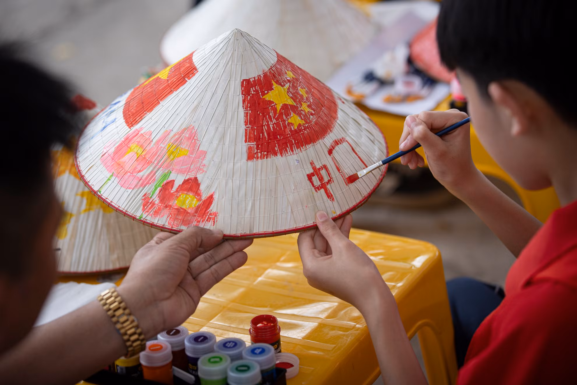 Một học sinh của đoàn Trung Quốc đang hoàn thành tác phẩm của mình.