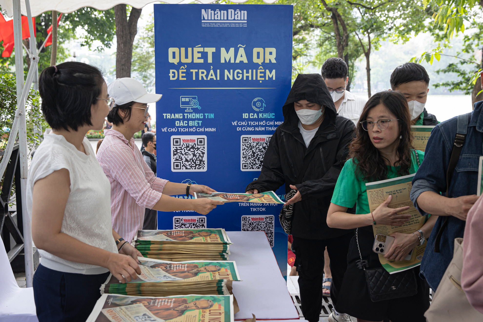 Cán bộ, phóng viên Báo Nhân Dân trao tận tay phụ san đặc biệt cho độc giả.