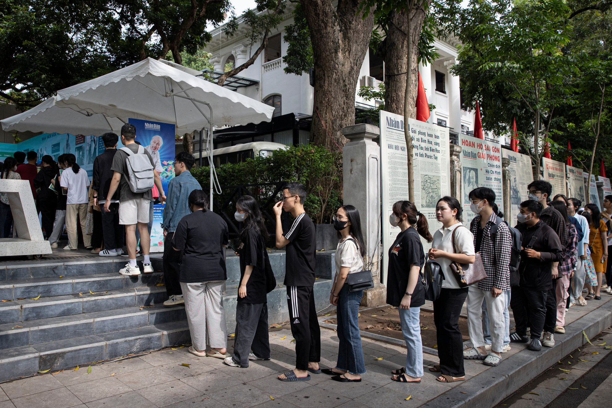 Nhiều bạn trẻ xếp hàng từ sớm để nhận ấn phẩm đặc biệt và tham quan Triển lãm ảnh “Rạng rỡ tên Người”.