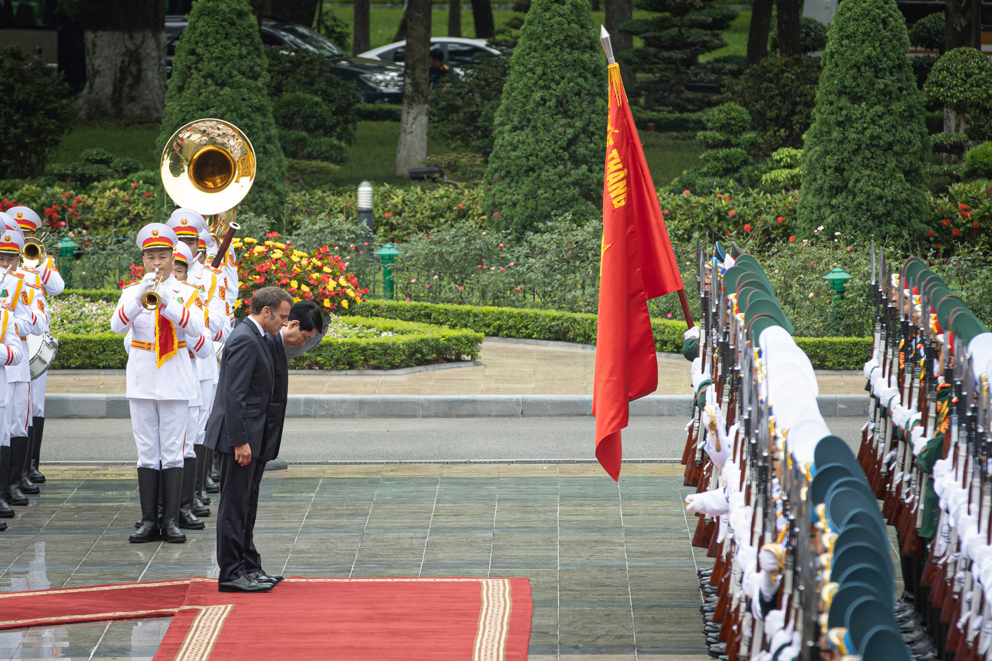 Chủ tịch nước Lương Cường và Tổng thống Pháp Emmanuel Macron cúi chào Quân kỳ Quyết thắng.