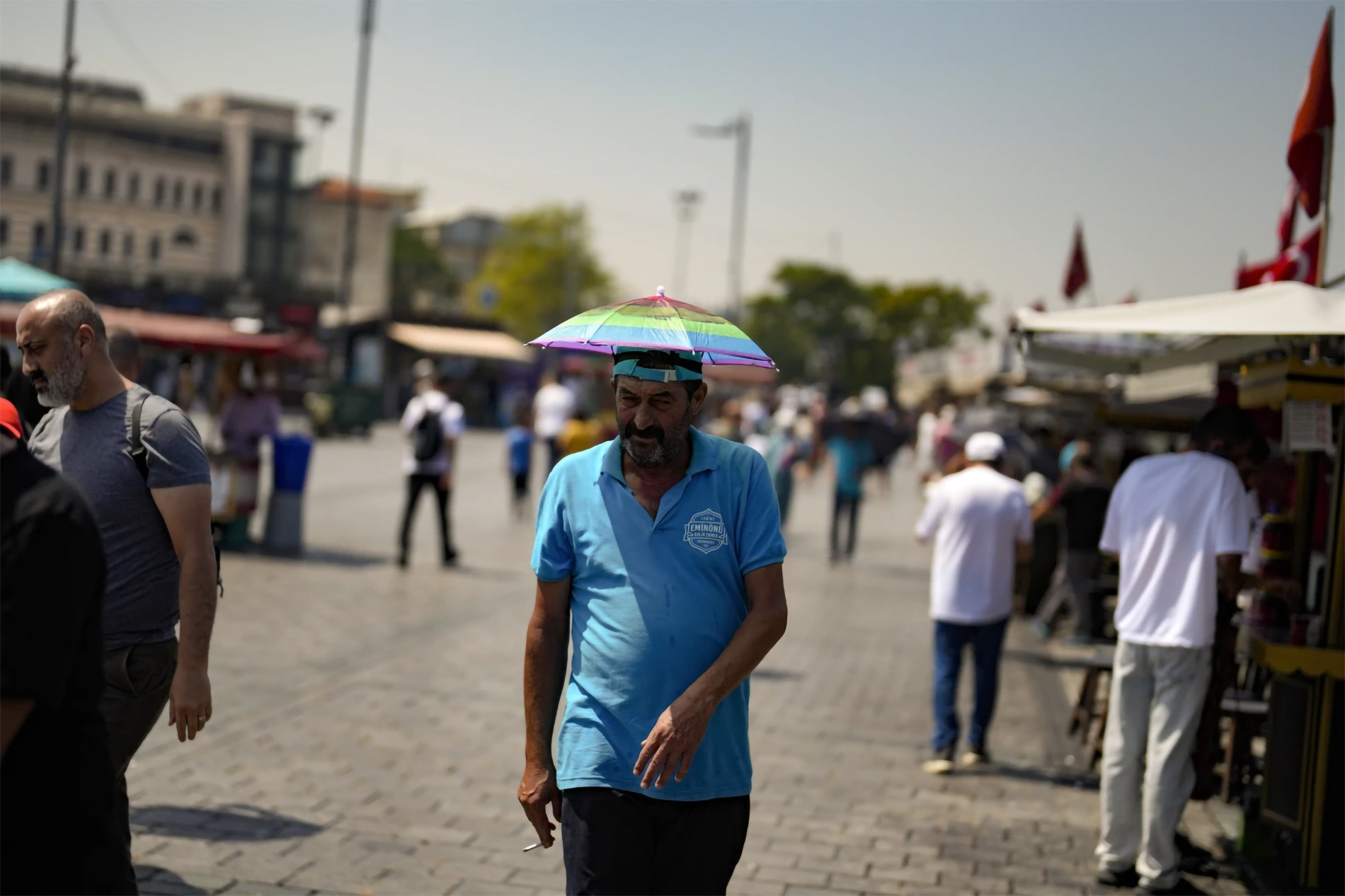 Người đàn ông đội ô trên đầu để che nắng khi di chuyển tại quận Eminonu, Istanbul, Thổ Nhĩ Kỳ, ngày 20/7/2023. (Ảnh: AP)