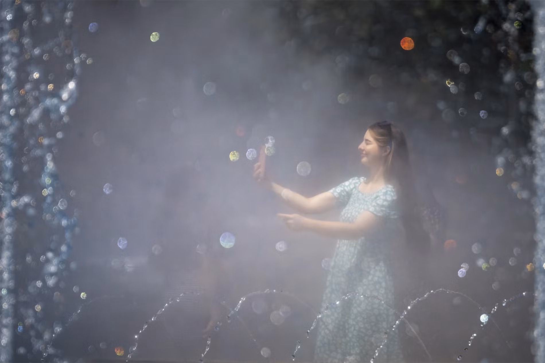 Cô gái chụp ảnh bên đài phun nước công cộng ở Bucharest, Romania, ngày 17/7/2023. (Ảnh: AP)